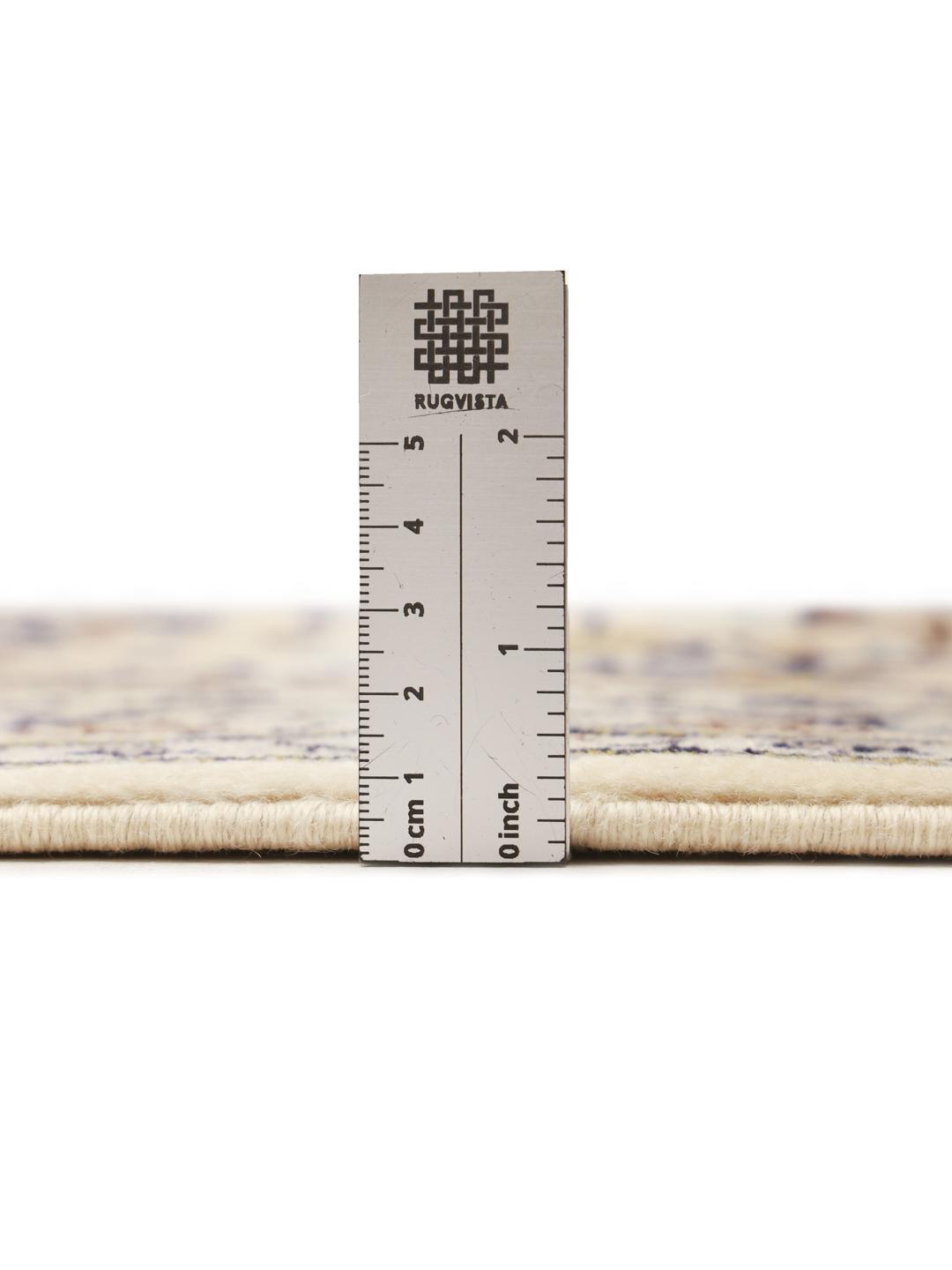 A hand-knotted Keshan rug from the Middle East with a cream background and floral motifs.