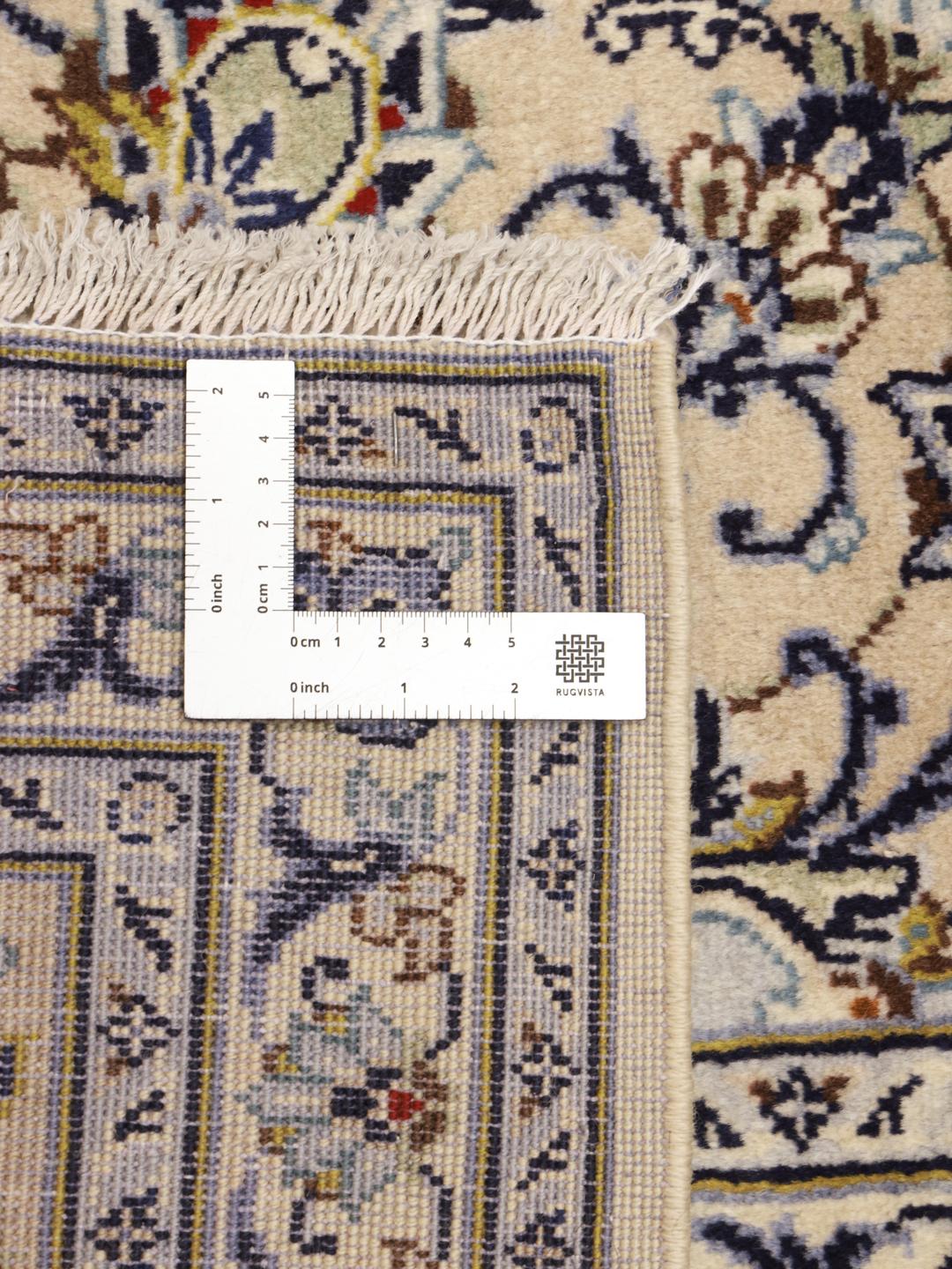 A hand-knotted Keshan rug from the Middle East with a cream background and floral motifs.
