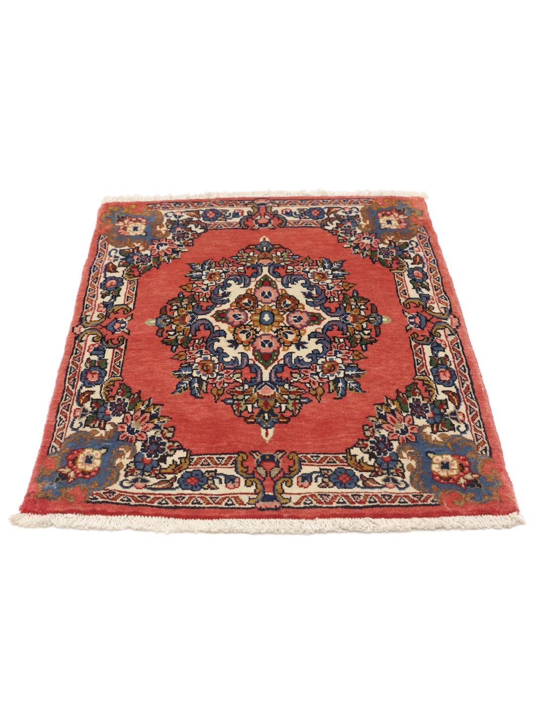 A hand-knotted Sarough rug from the Middle East featuring a vibrant red field and a detailed floral medallion.