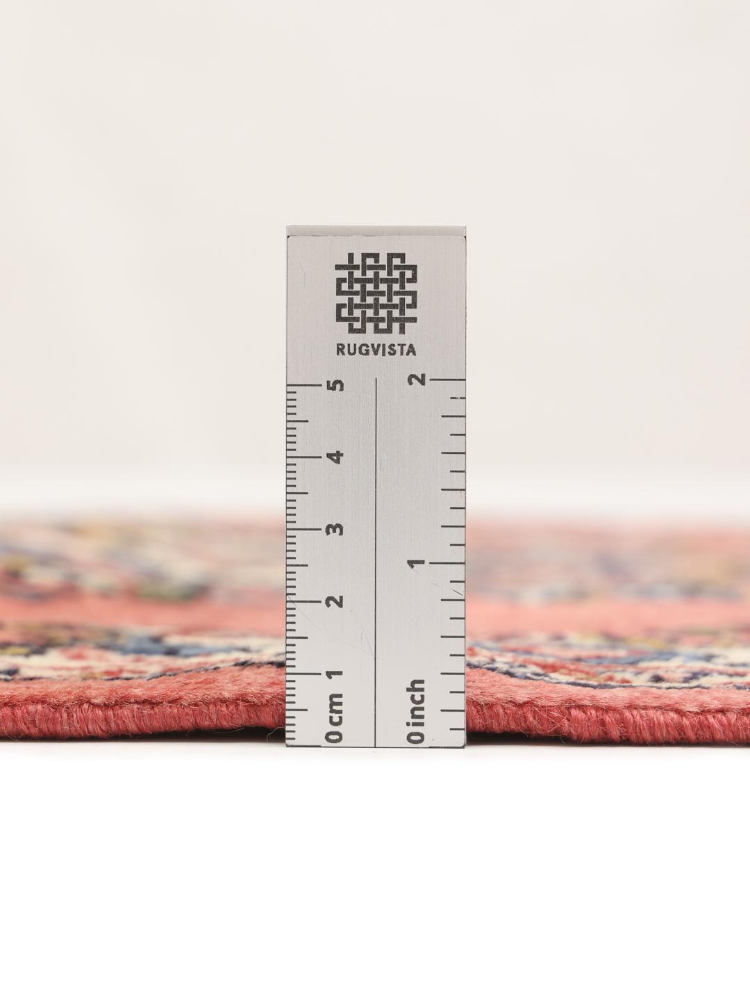 A hand-knotted Sarough rug from the Middle East featuring a vibrant red field and a detailed floral medallion.