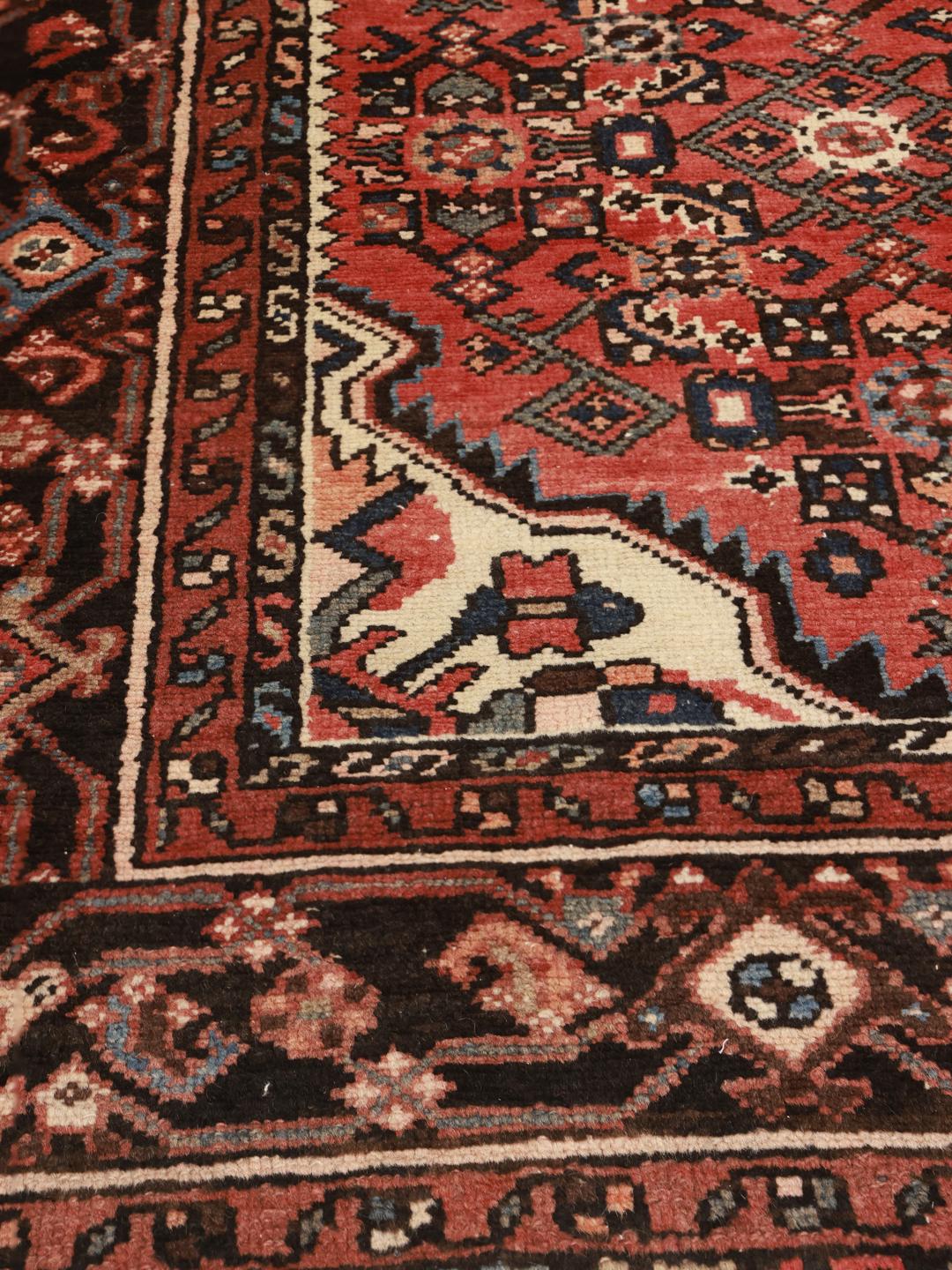 Hand-knotted Middle Eastern Hosseinabad rug in red and dark-blue tones.