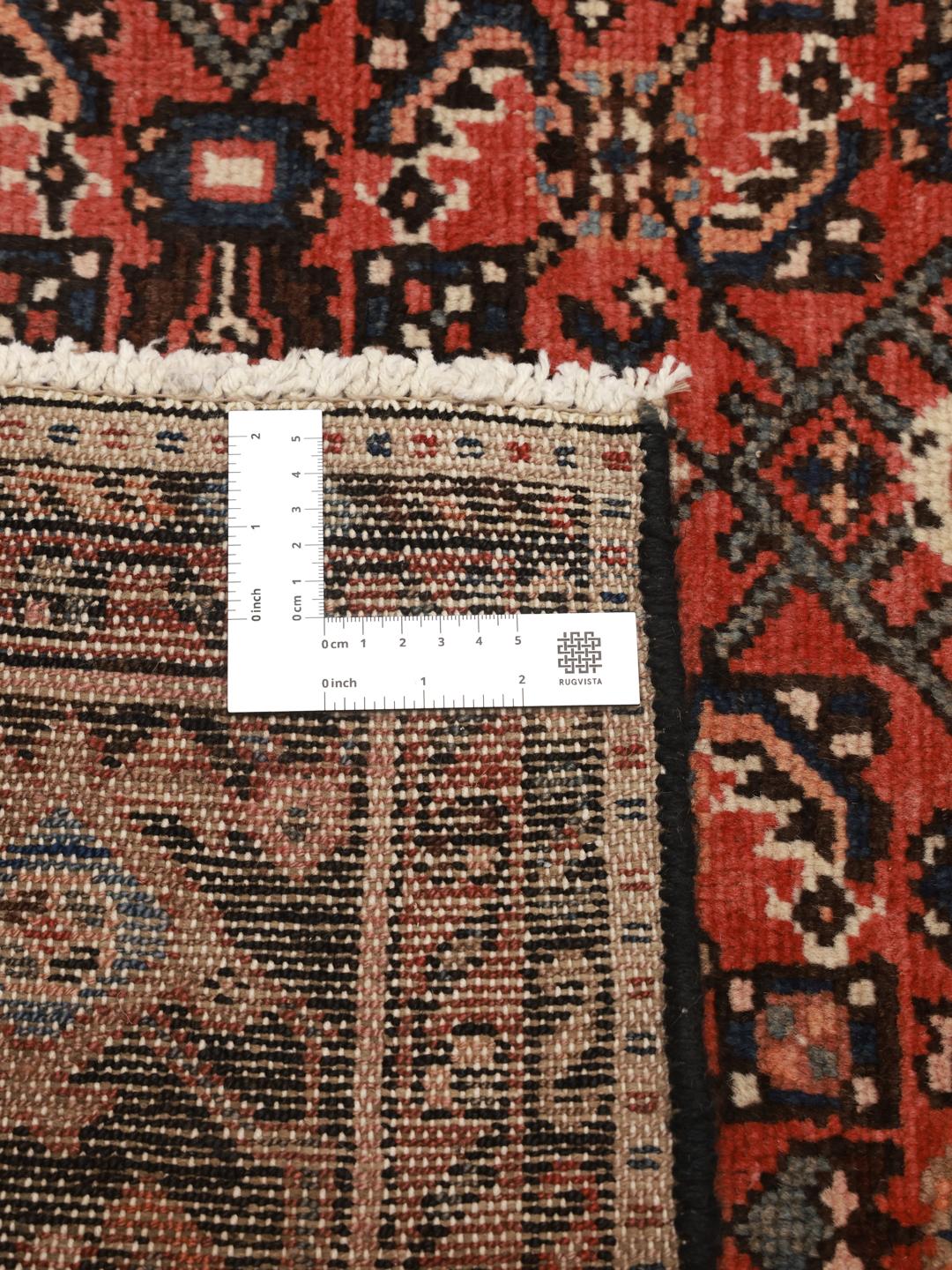 Hand-knotted Middle Eastern Hosseinabad rug in red and dark-blue tones.