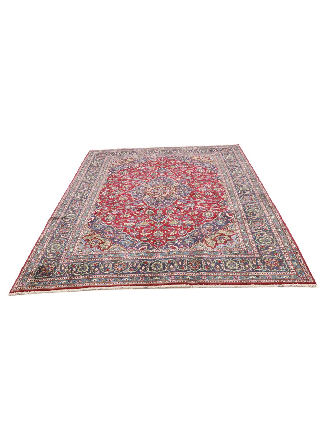 A hand-knotted Mashad rug from the Middle East with a deep red field and ornate patterns.