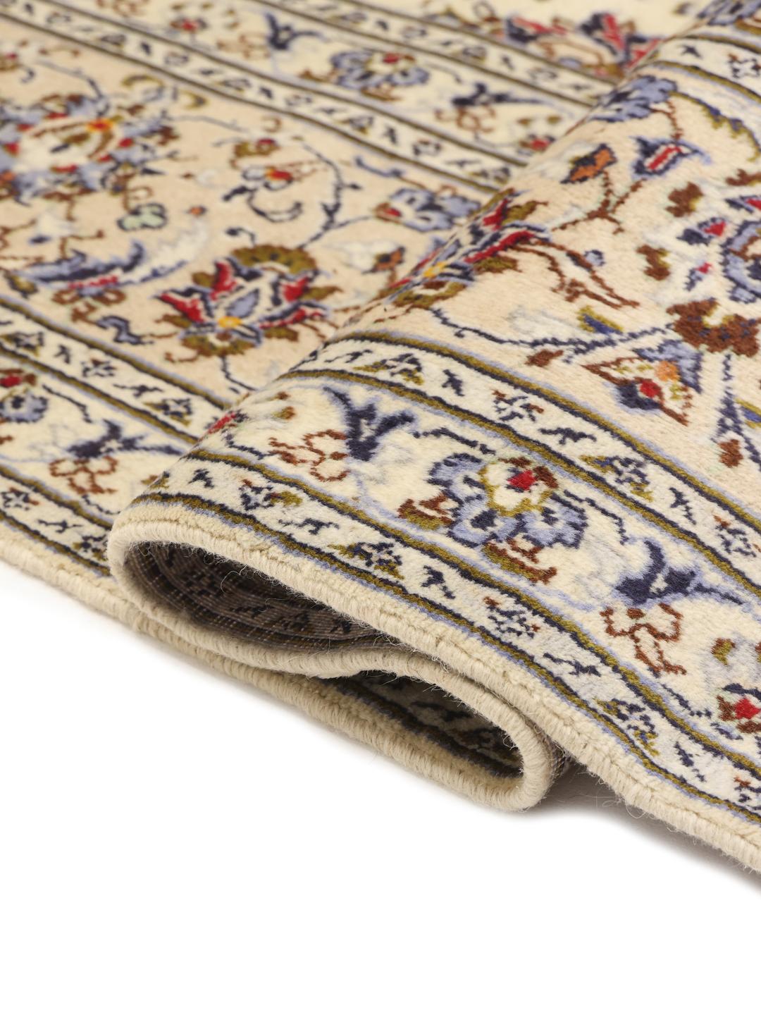 A large rectangular Keshan rug with a beige field and intricate floral medallion from the Middle East.