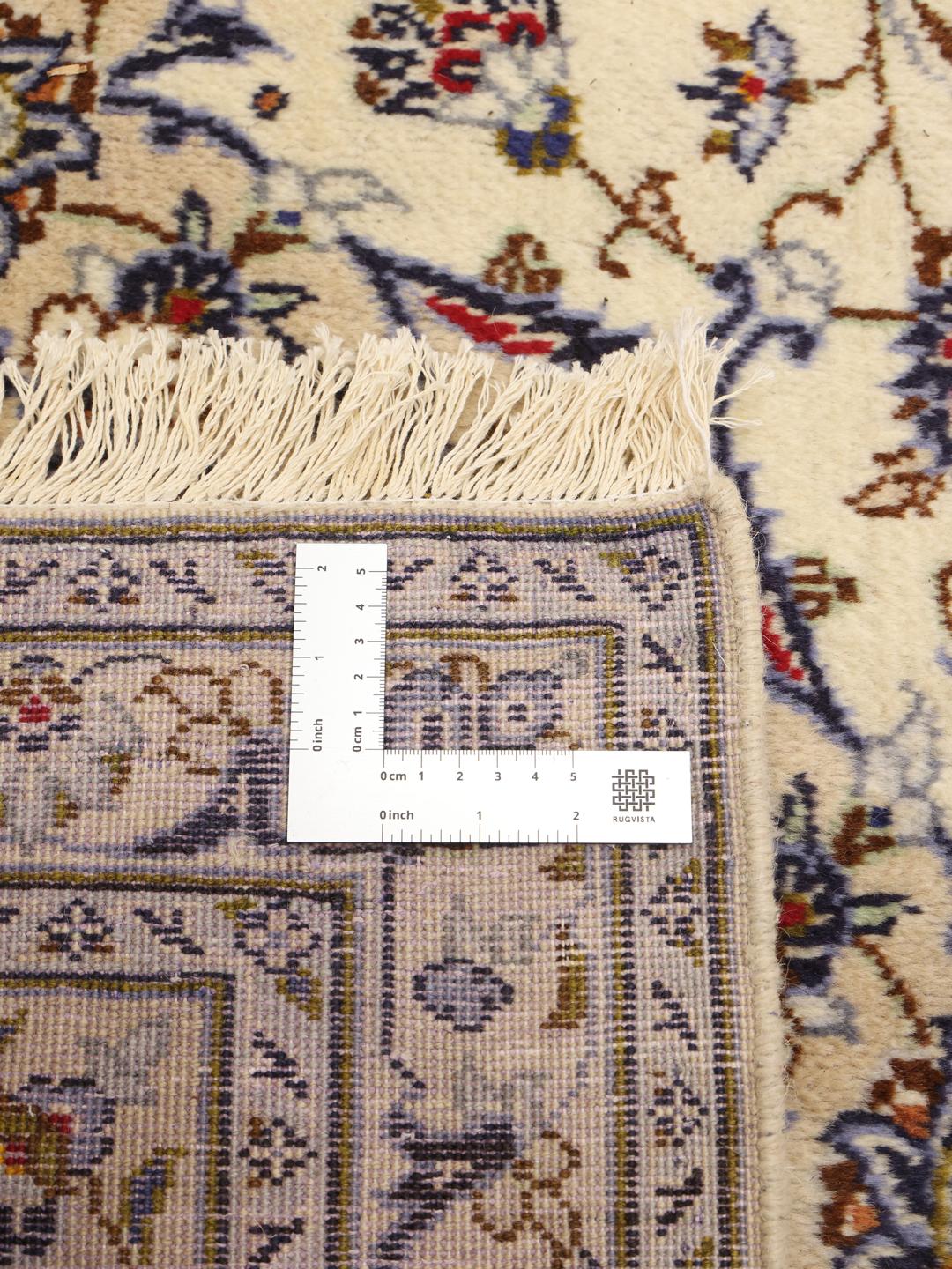 A large rectangular Keshan rug with a beige field and intricate floral medallion from the Middle East.