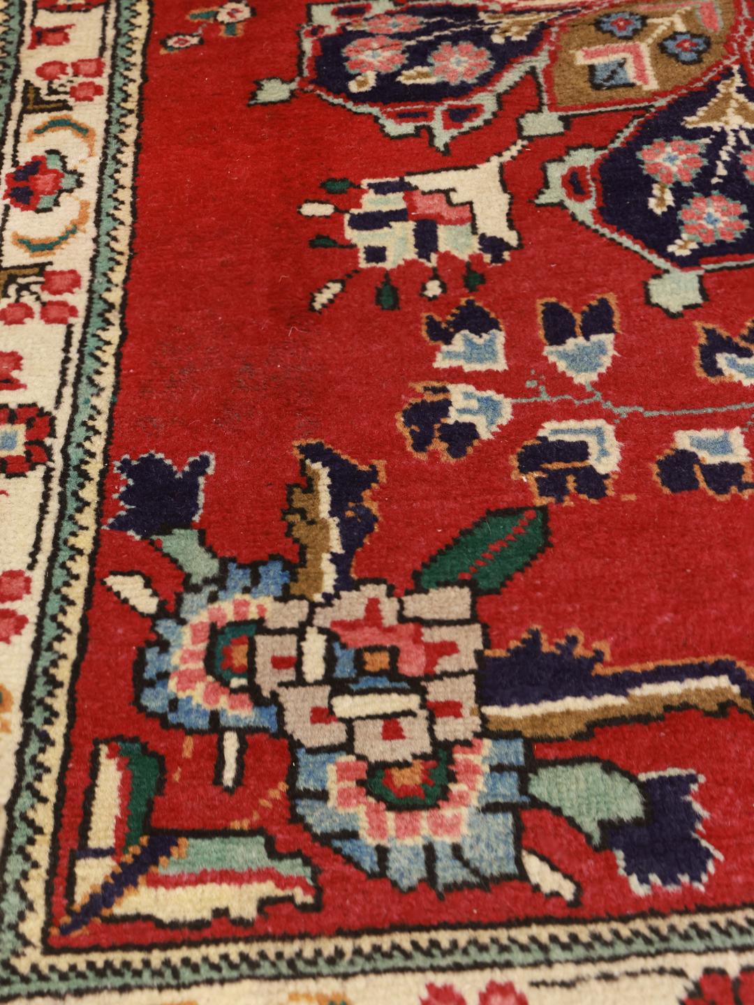 Handgeknoopt Lillian-tapijt met een levendig rood veld en bloemenmedaillon uit het Midden-Oosten.