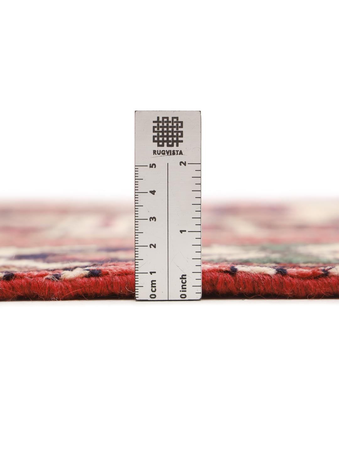 Een handgeknoopt Hamadan-tapijt uit het Midden-Oosten met een rood veld en traditionele geometrische motieven.