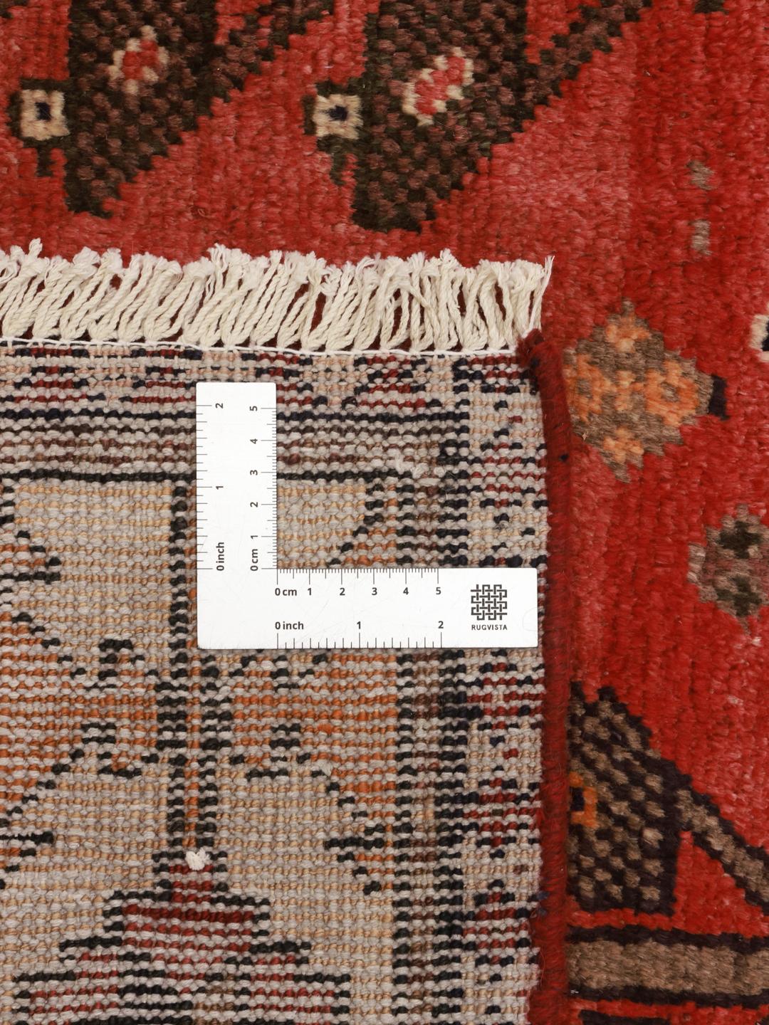Een handgeknoopt Hamadan-tapijt uit het Midden-Oosten met een rood veld en traditionele geometrische motieven.