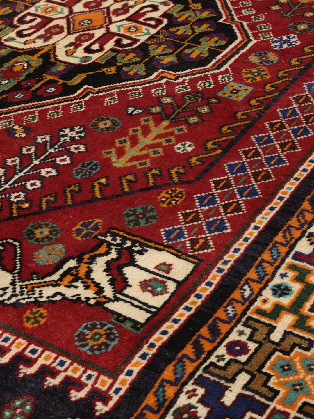 Hand-knotted Ghashghai rug from the Middle East with a red and dark-blue wool pile