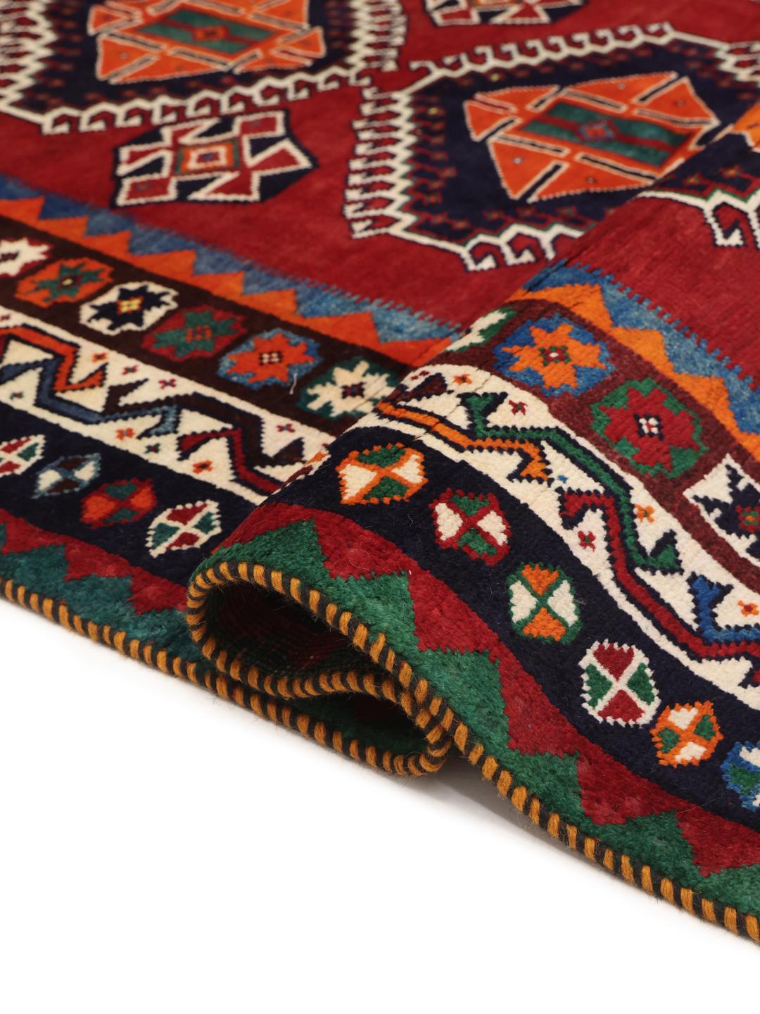 Hand-knotted Qashqai rug from the Middle East with a red field and geometric patterns