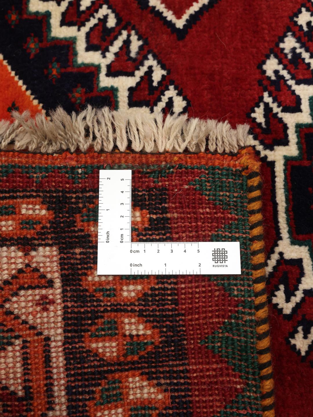 Hand-knotted Qashqai rug from the Middle East with a red field and geometric patterns