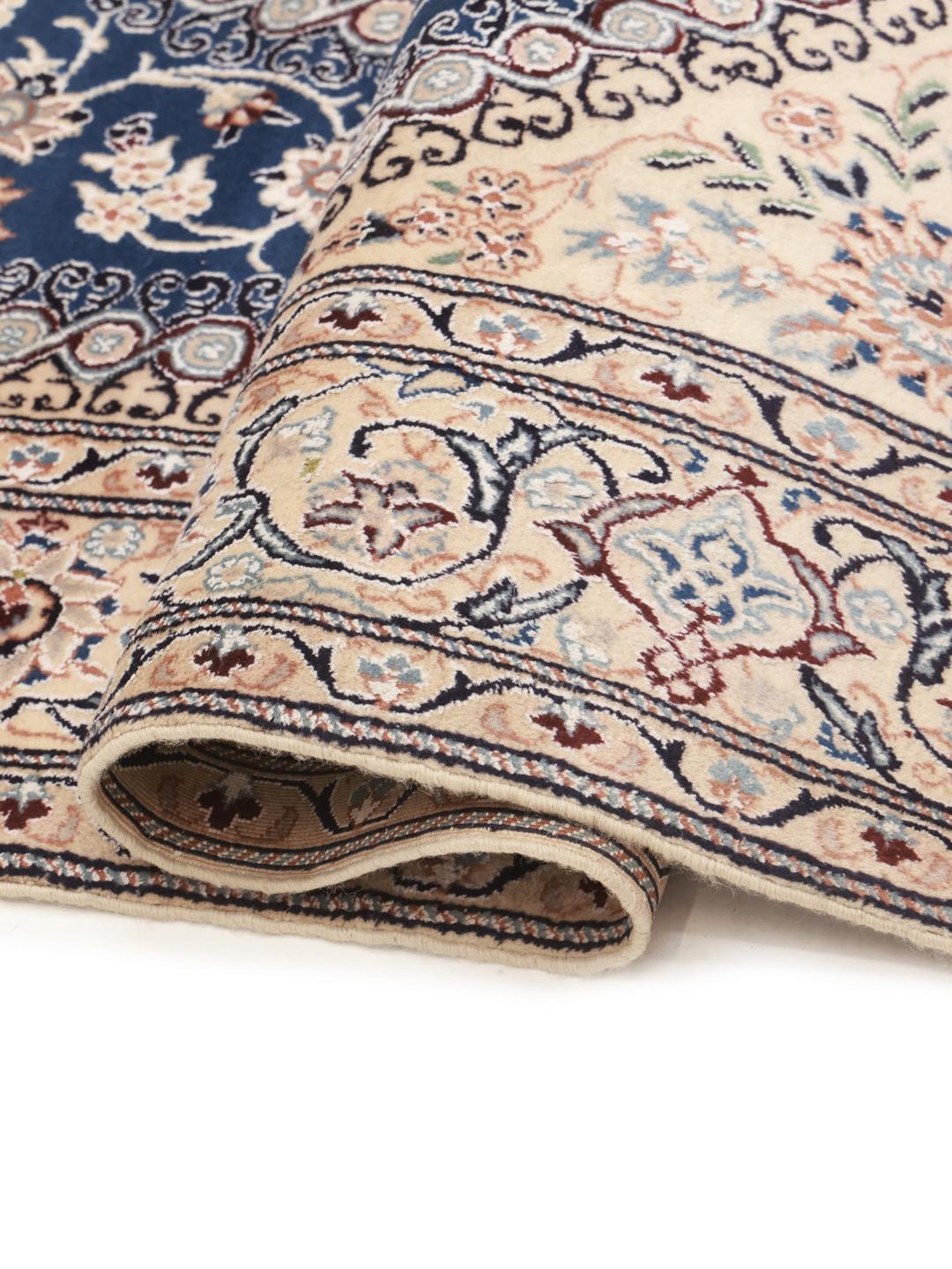 Hand-knotted Nain rug with a deep blue medallion and cream background from the Middle East