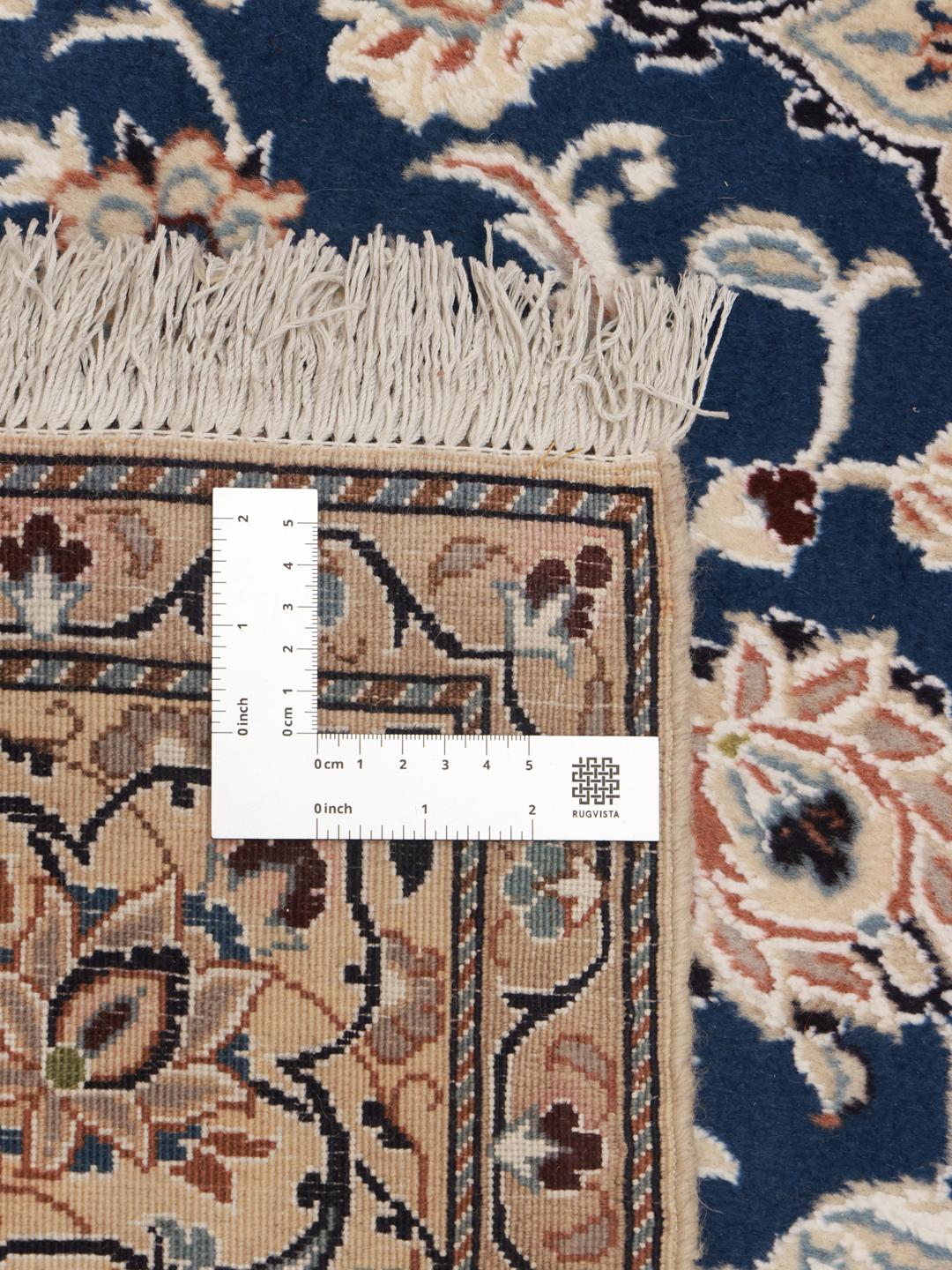 Hand-knotted Nain rug with a deep blue medallion and cream background from the Middle East