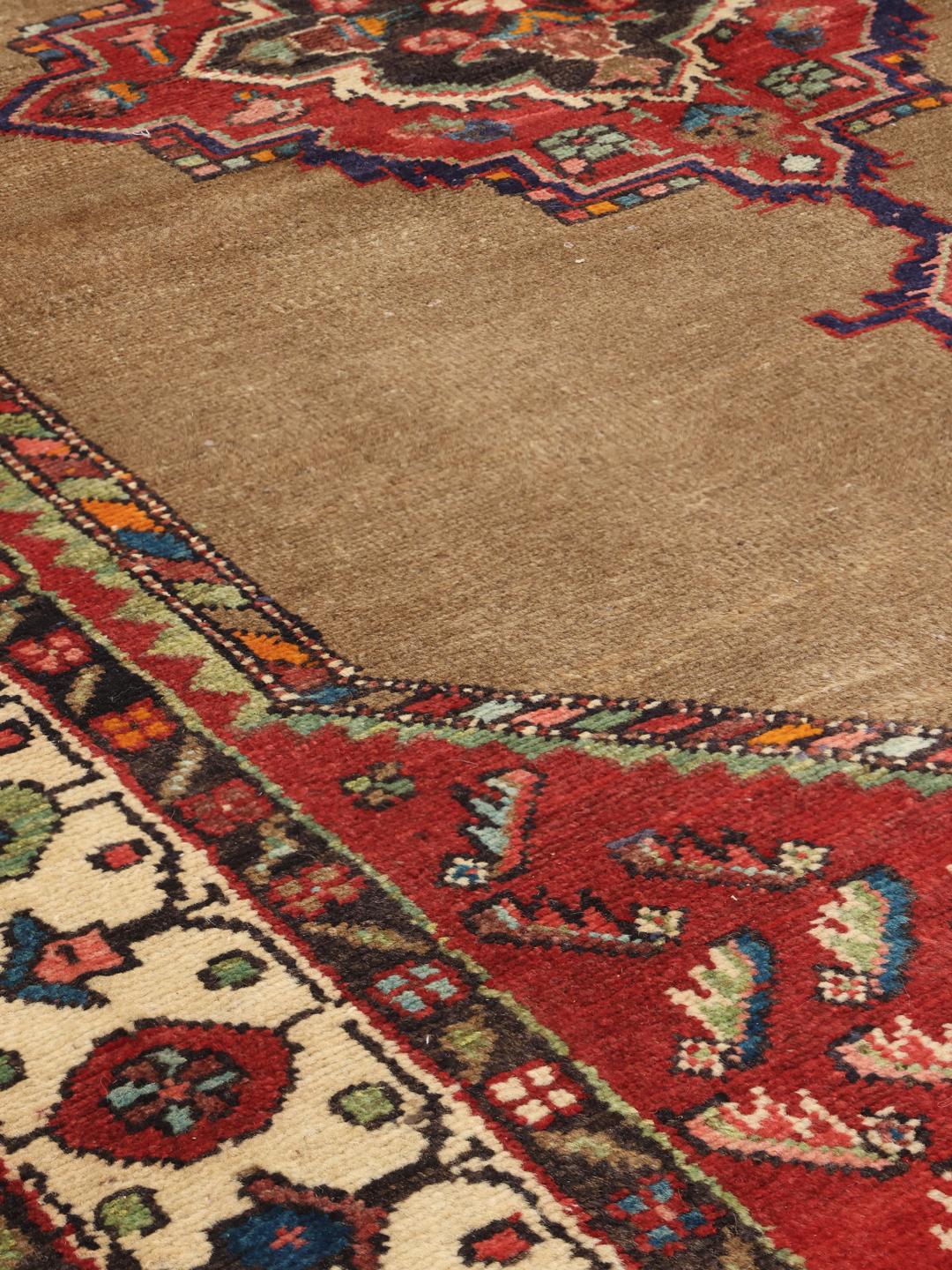 Hand-knotted wool rug from the Middle East in warm brown and red tones