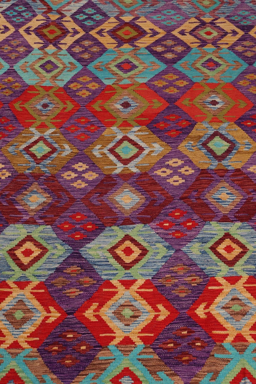 Een handgeweven, veelkleurig Afghaans Kelim-tapijt met geometrische motieven.