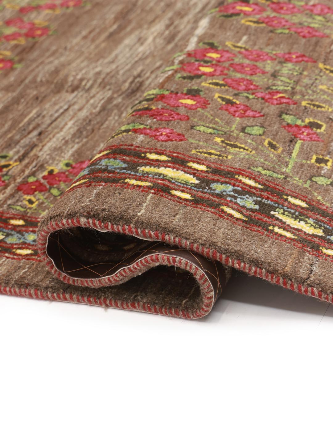Hand-knotted Loribaft rug from the Middle East featuring floral patterns on a brown background.