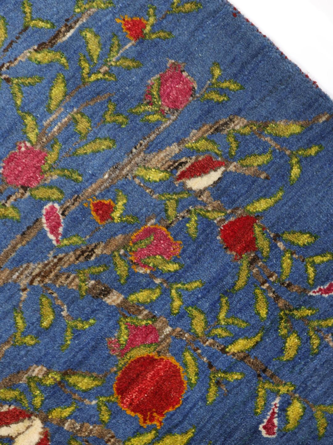 A hand-knotted Loribaft rug from the Middle East featuring a Tree of Life design on a blue field.