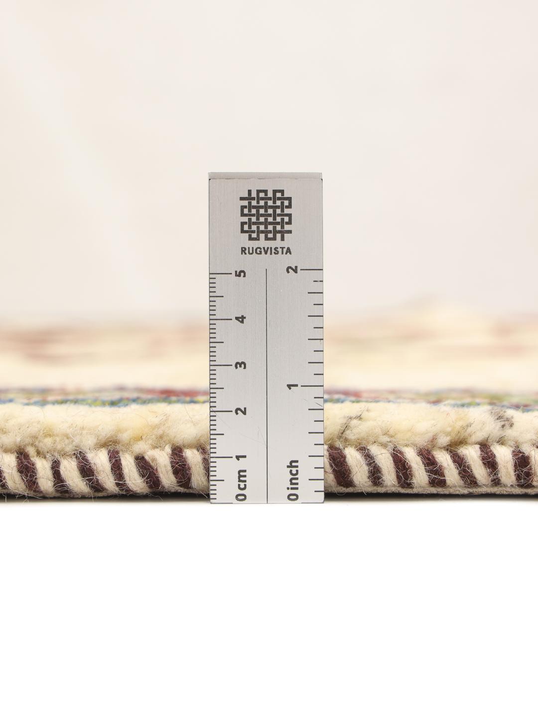 Handgeknoopt Loribaft-tapijt met een levensboommotief in beige, rode en groene tinten.