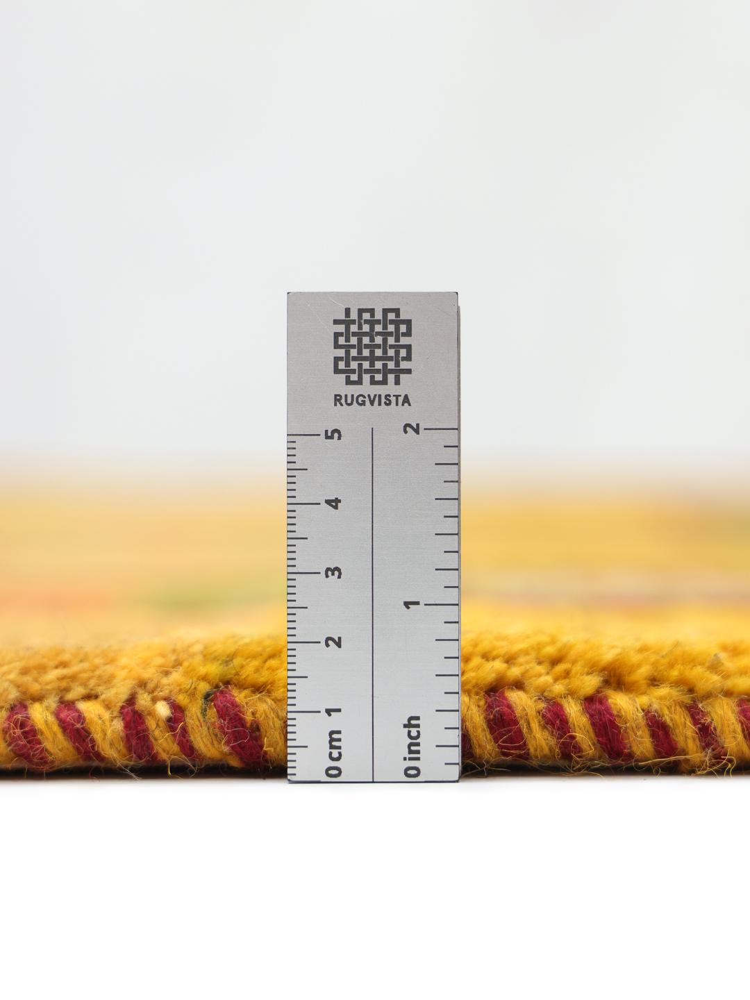 Handgeknoopt geel Loribaft-tapijt met tribale motieven en groene randpanelen uit het Midden-Oosten
