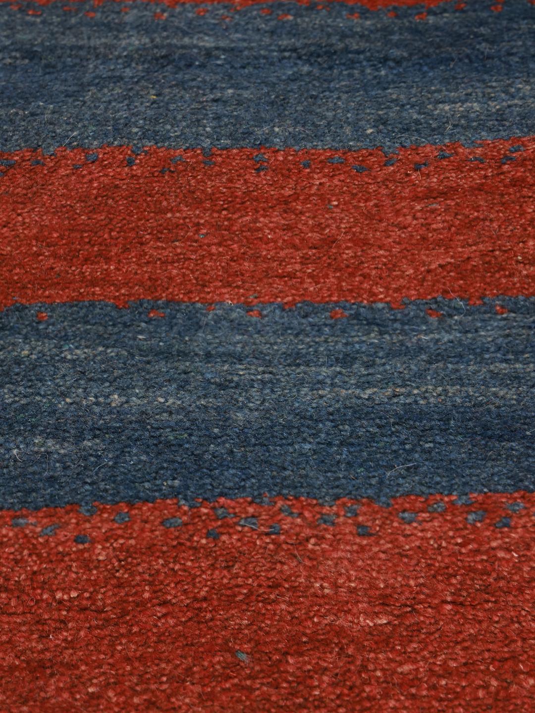 Een handgeknoopt Gabbeh kleed uit het Midden-Oosten met horizontale rode en blauwe strepen