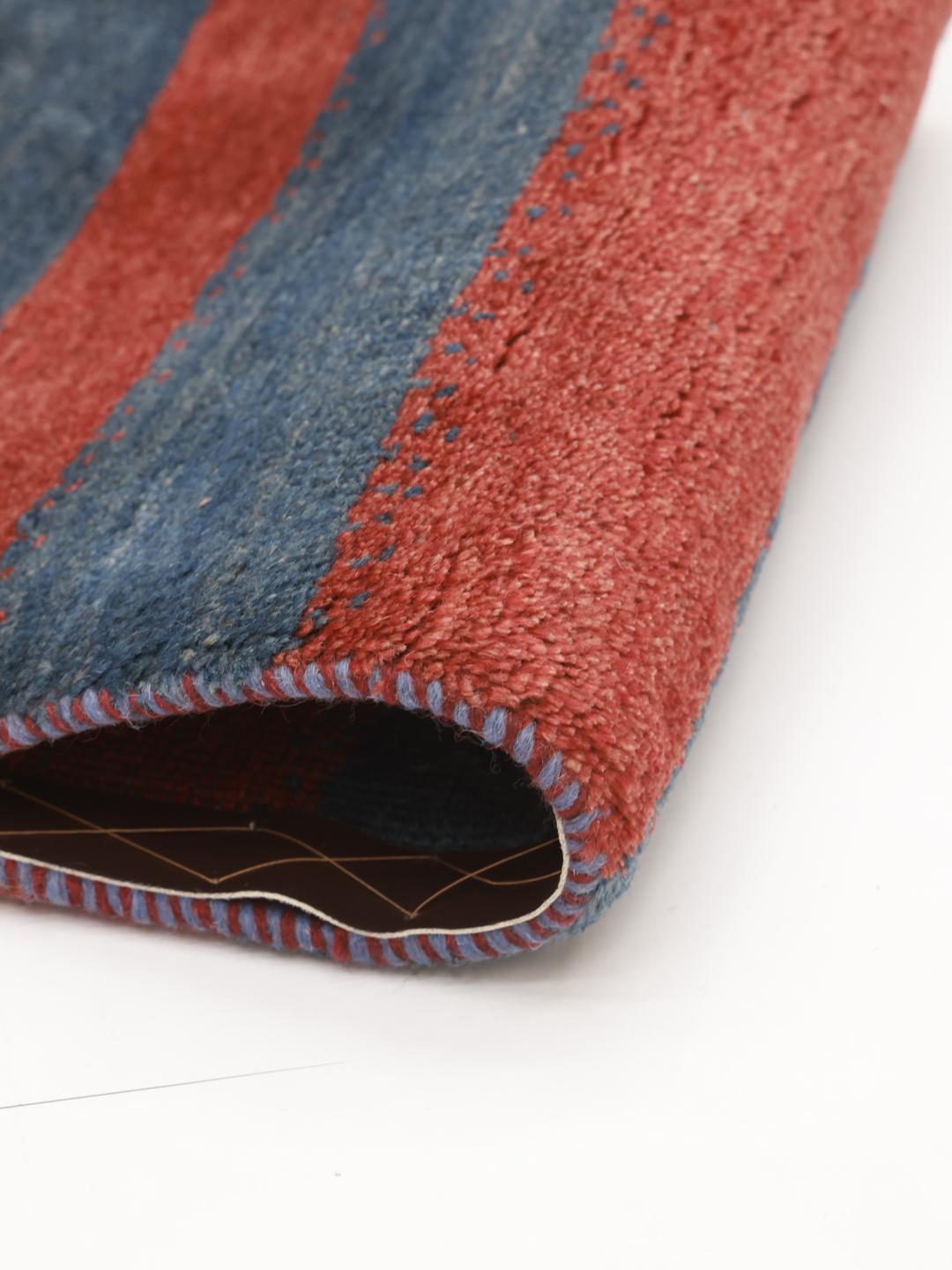 Een handgeknoopt Gabbeh kleed uit het Midden-Oosten met horizontale rode en blauwe strepen