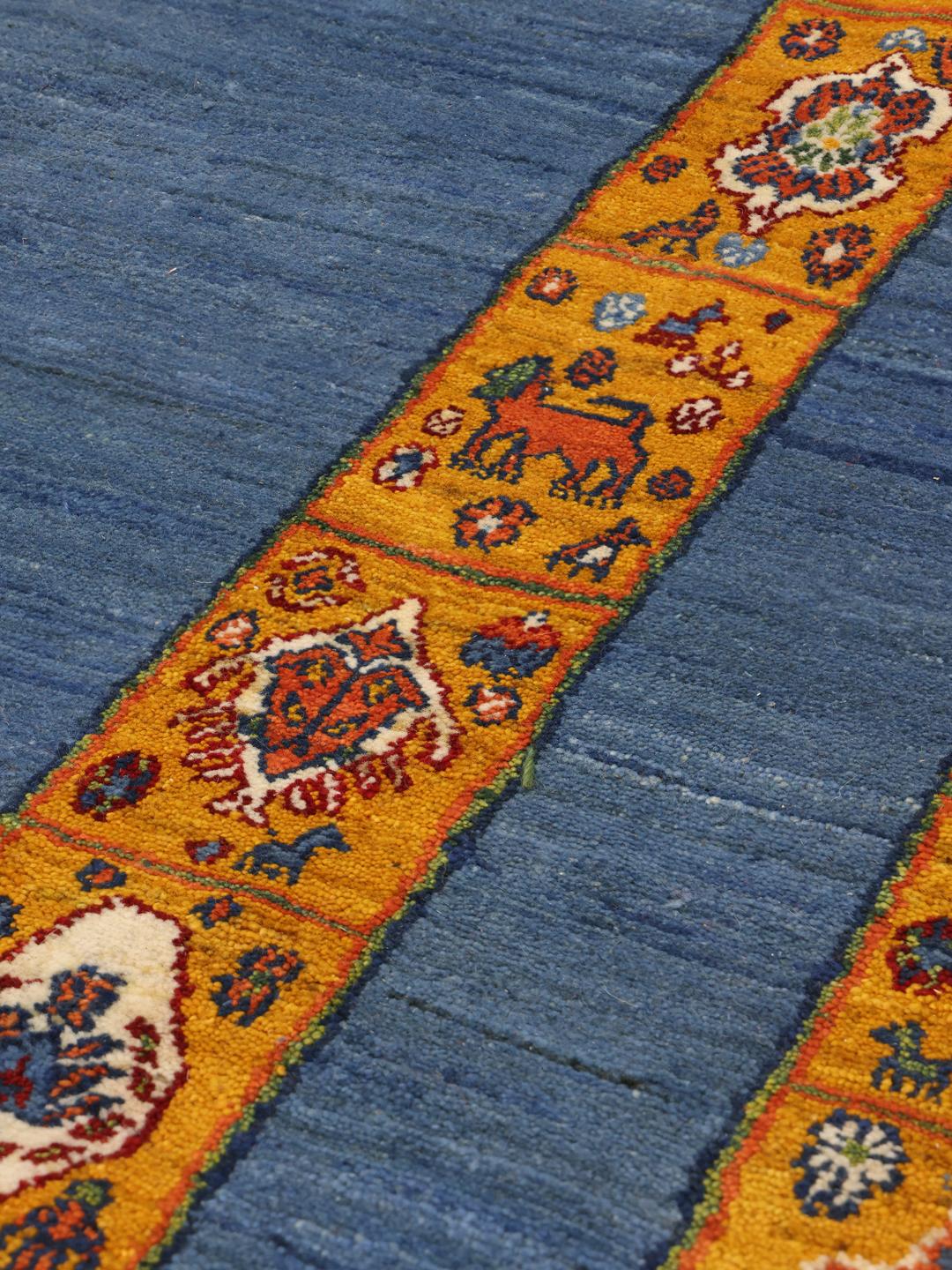 Handgeknoopt Loribaft-tapijt uit het Midden-Oosten met een diepblauw veld en gele rand.