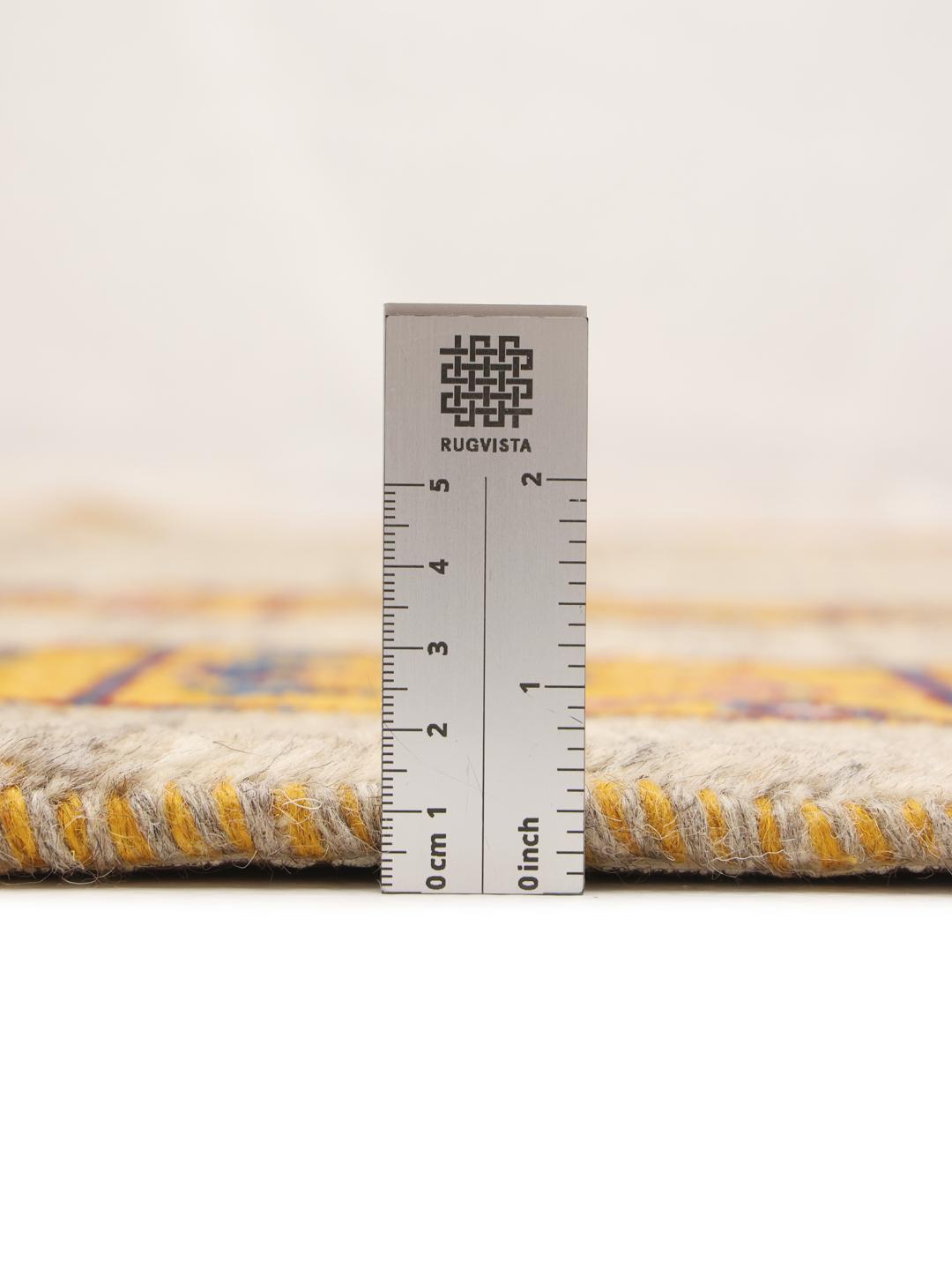 Et håndknyttet Loribaft-tæppe med et beige felt og en livlig, mønstret kant.