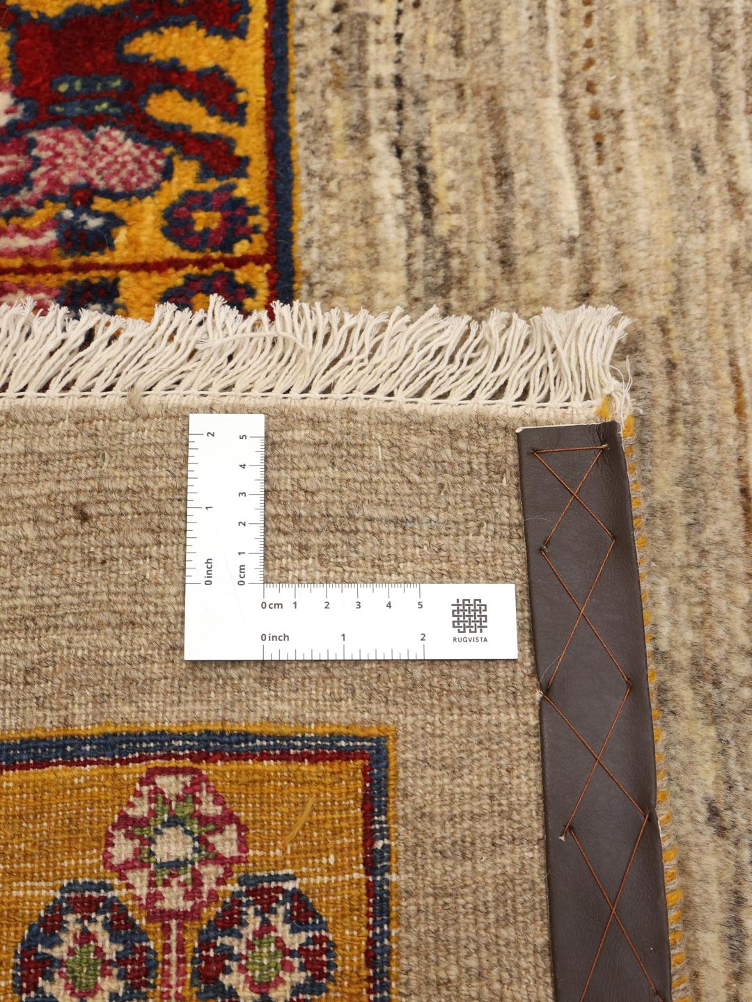 Et håndknyttet Loribaft-tæppe med et beige felt og en livlig, mønstret kant.