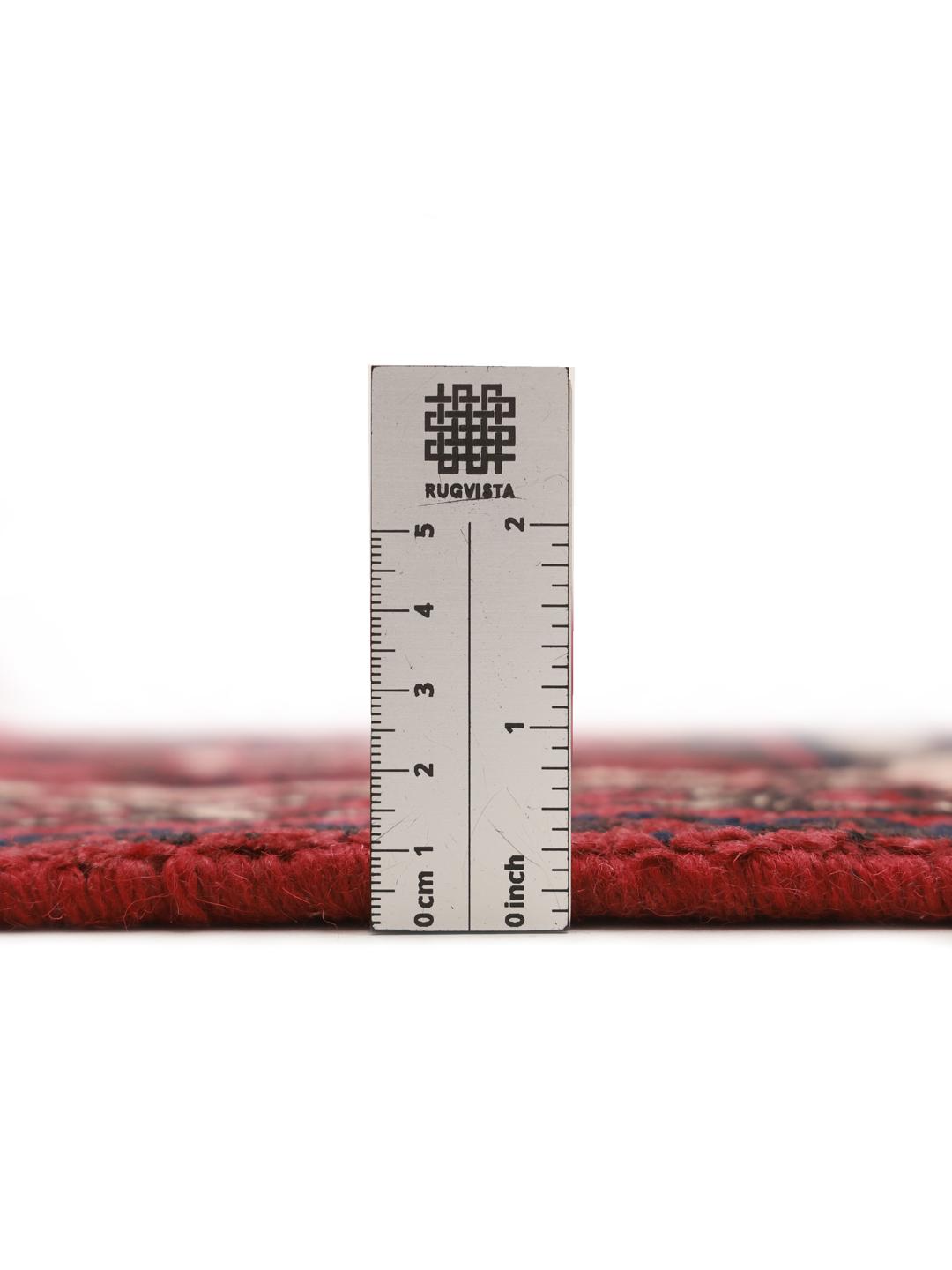 Een handgeknoopt Joshaghan-tapijt uit het Midden-Oosten met een rood veld en geometrische bloempatronen.