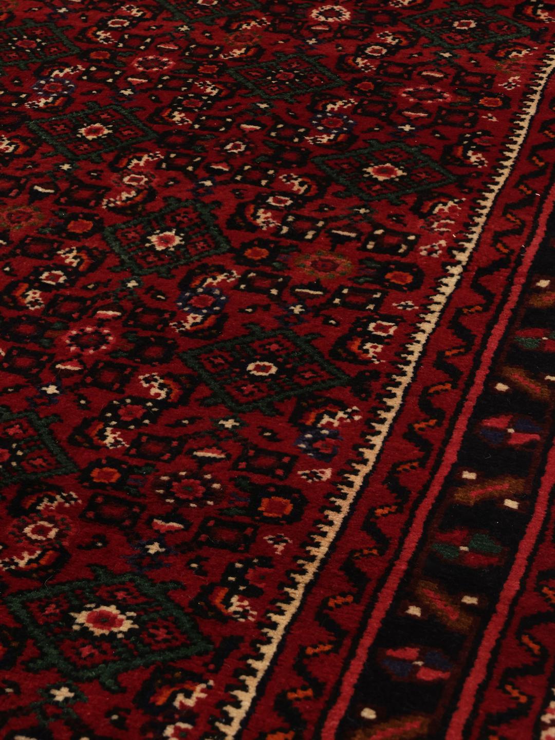 A long, hand-knotted Hosseinabad runner with a dark-red Wool pile and traditional Middle Eastern motifs.