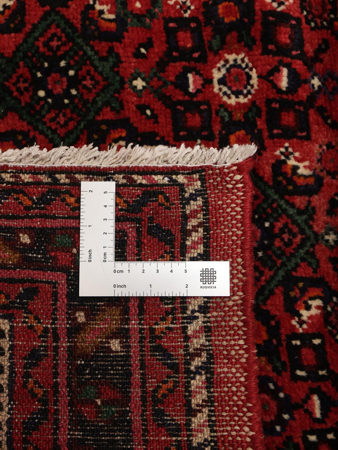 A long, hand-knotted Hosseinabad runner with a dark-red Wool pile and traditional Middle Eastern motifs.