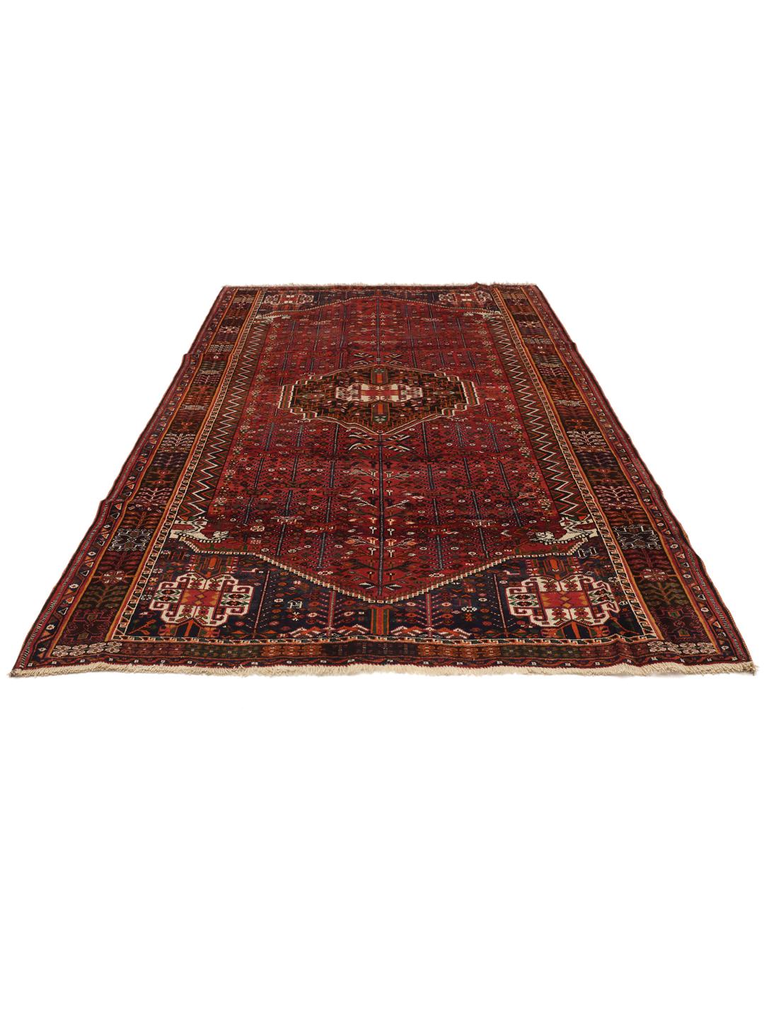 Hand-knotted Shiraz rug from the Middle East featuring a vibrant red field with geometric motifs.
