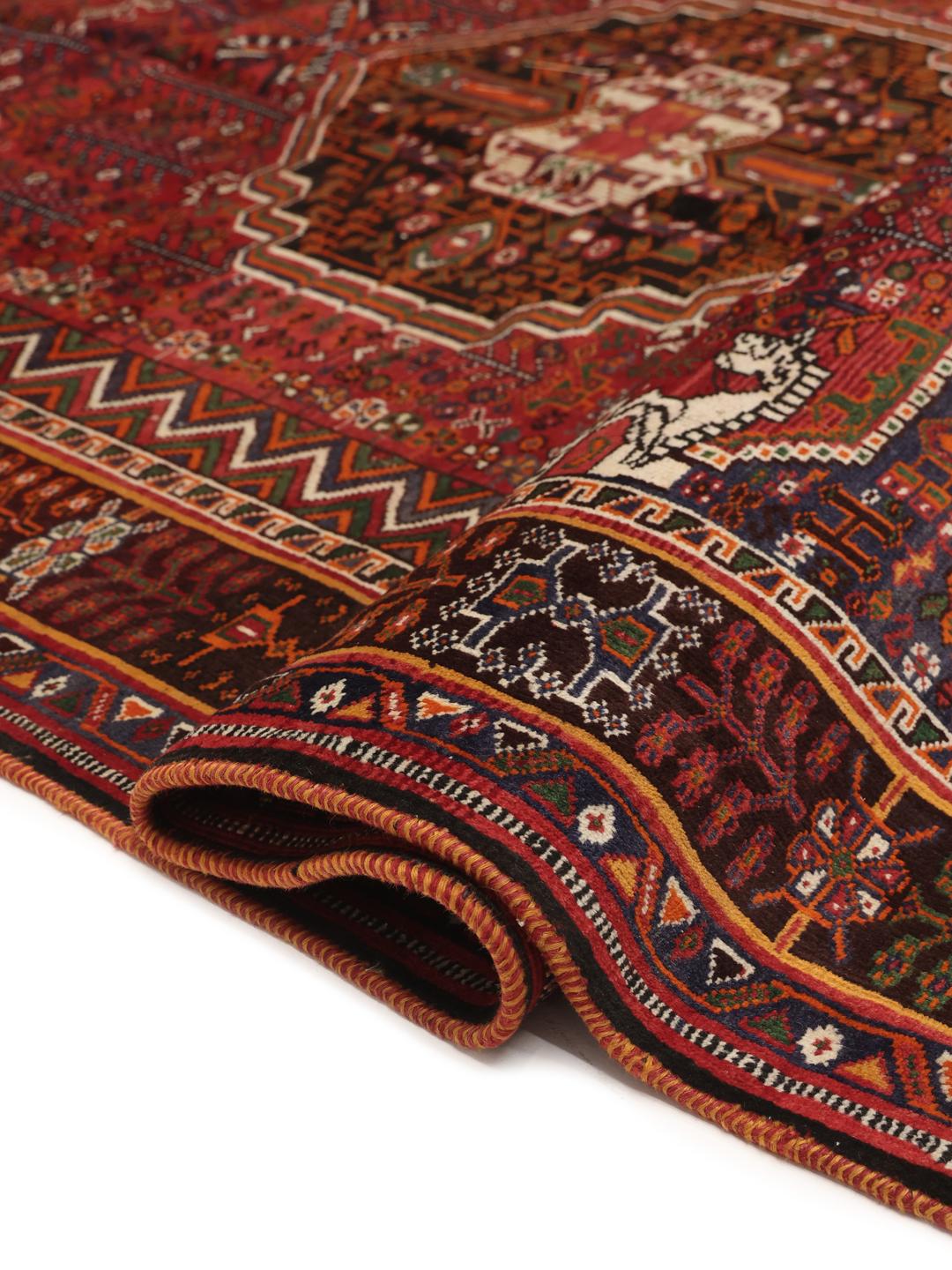 Hand-knotted Shiraz rug from the Middle East featuring a vibrant red field with geometric motifs.