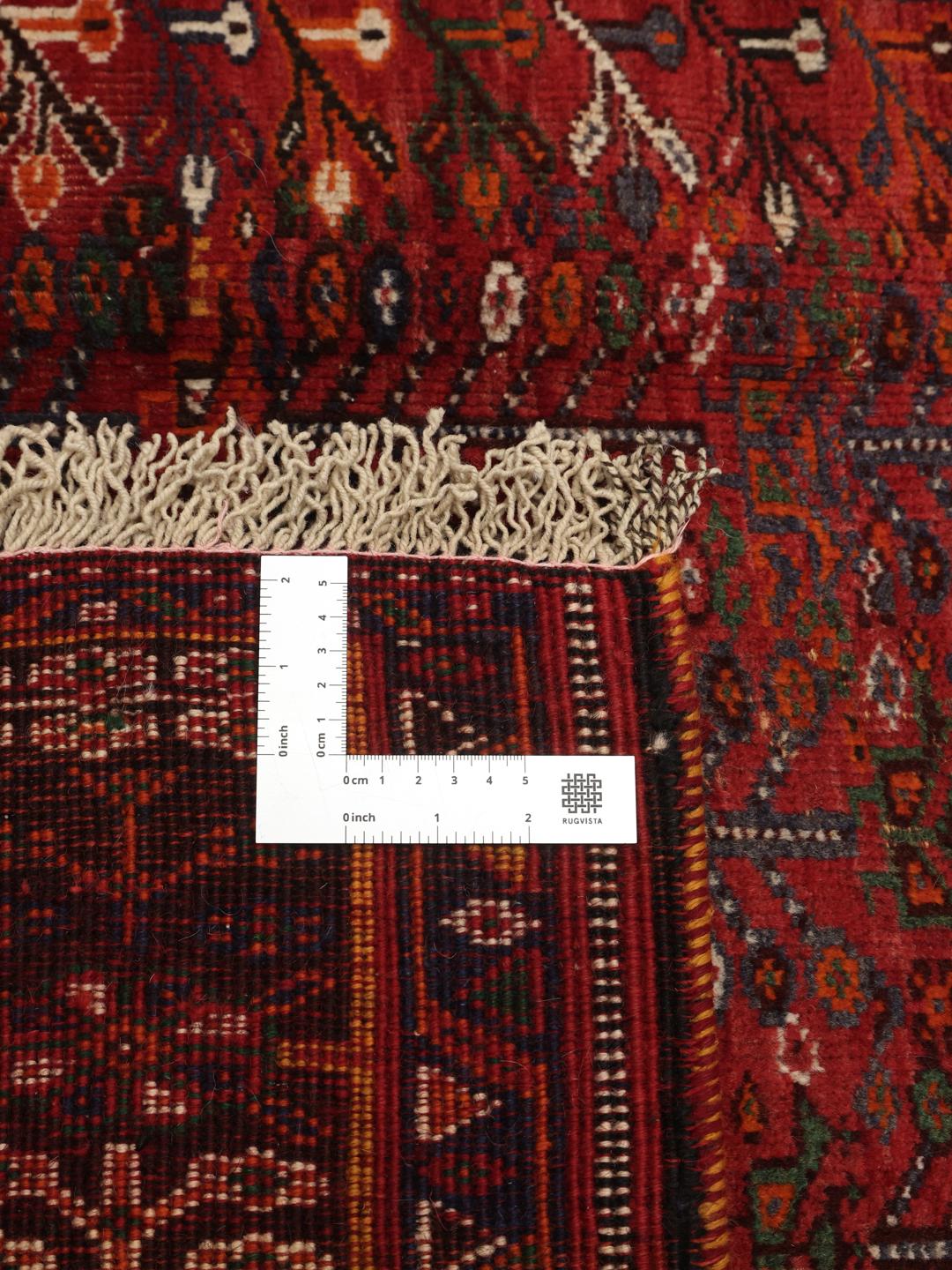 Hand-knotted Shiraz rug from the Middle East featuring a vibrant red field with geometric motifs.
