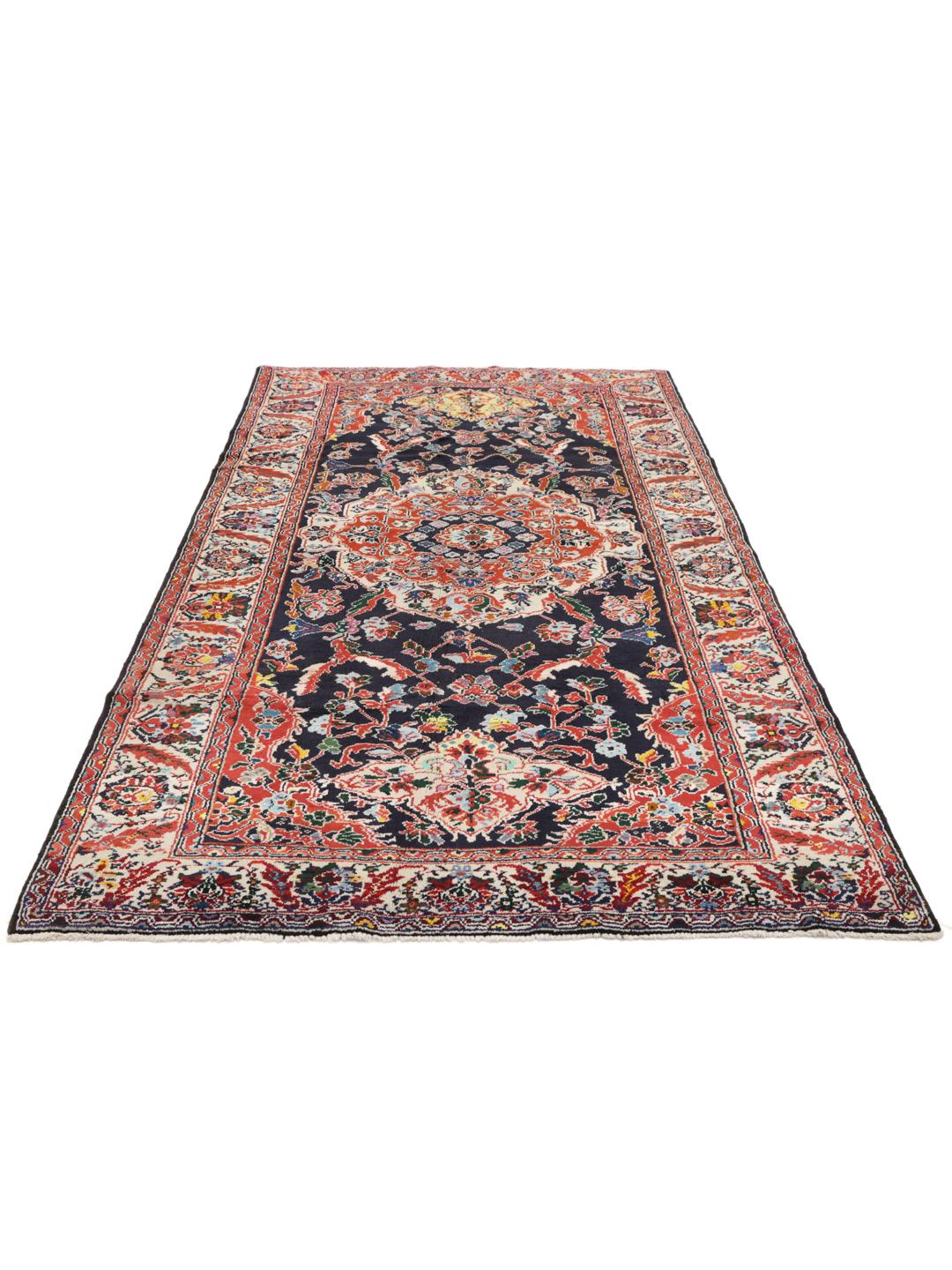 Hand-knotted Ardebil rug from the Middle East with a dark-blue and red floral medallion design.