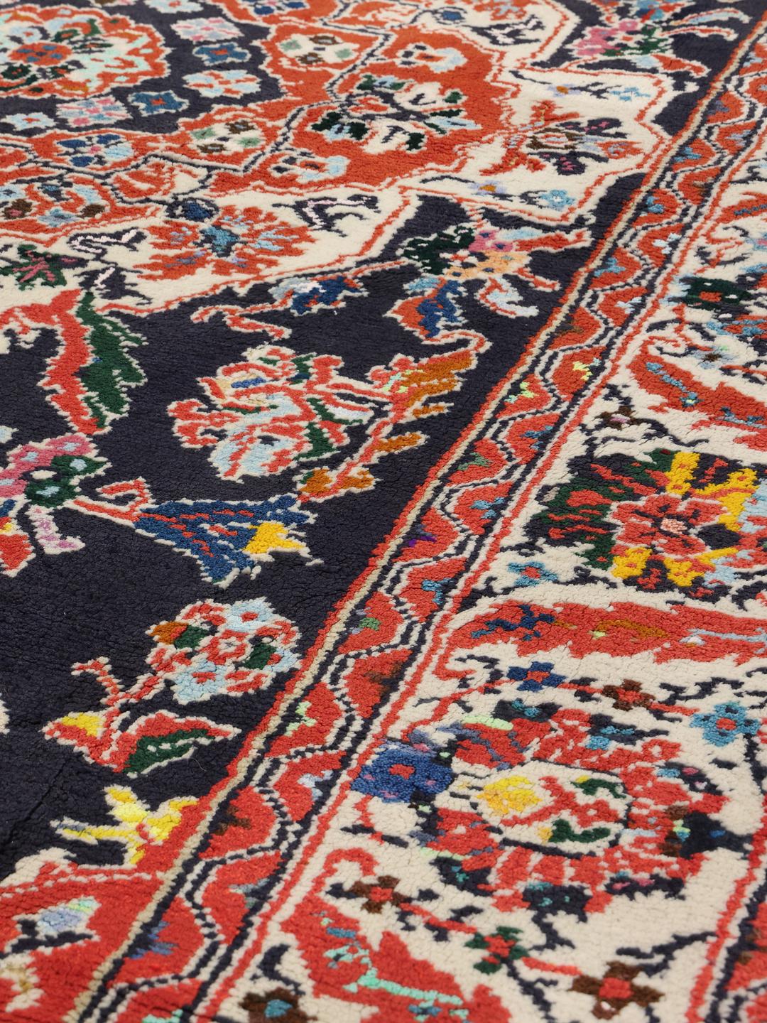 Hand-knotted Ardebil rug from the Middle East with a dark-blue and red floral medallion design.