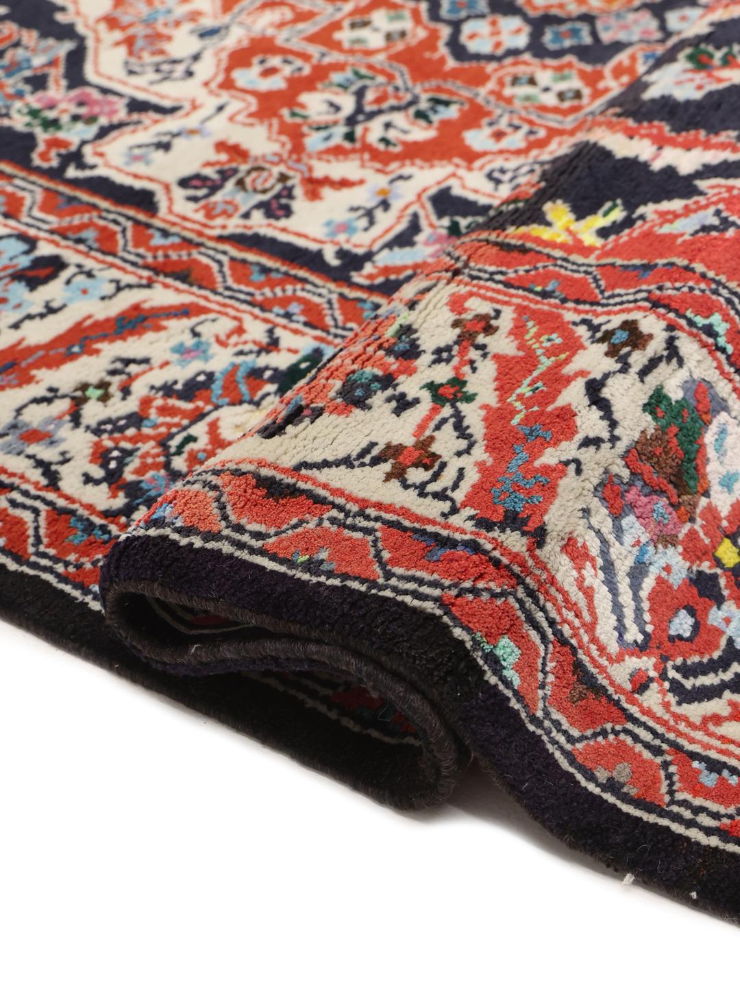 Hand-knotted Ardebil rug from the Middle East with a dark-blue and red floral medallion design.