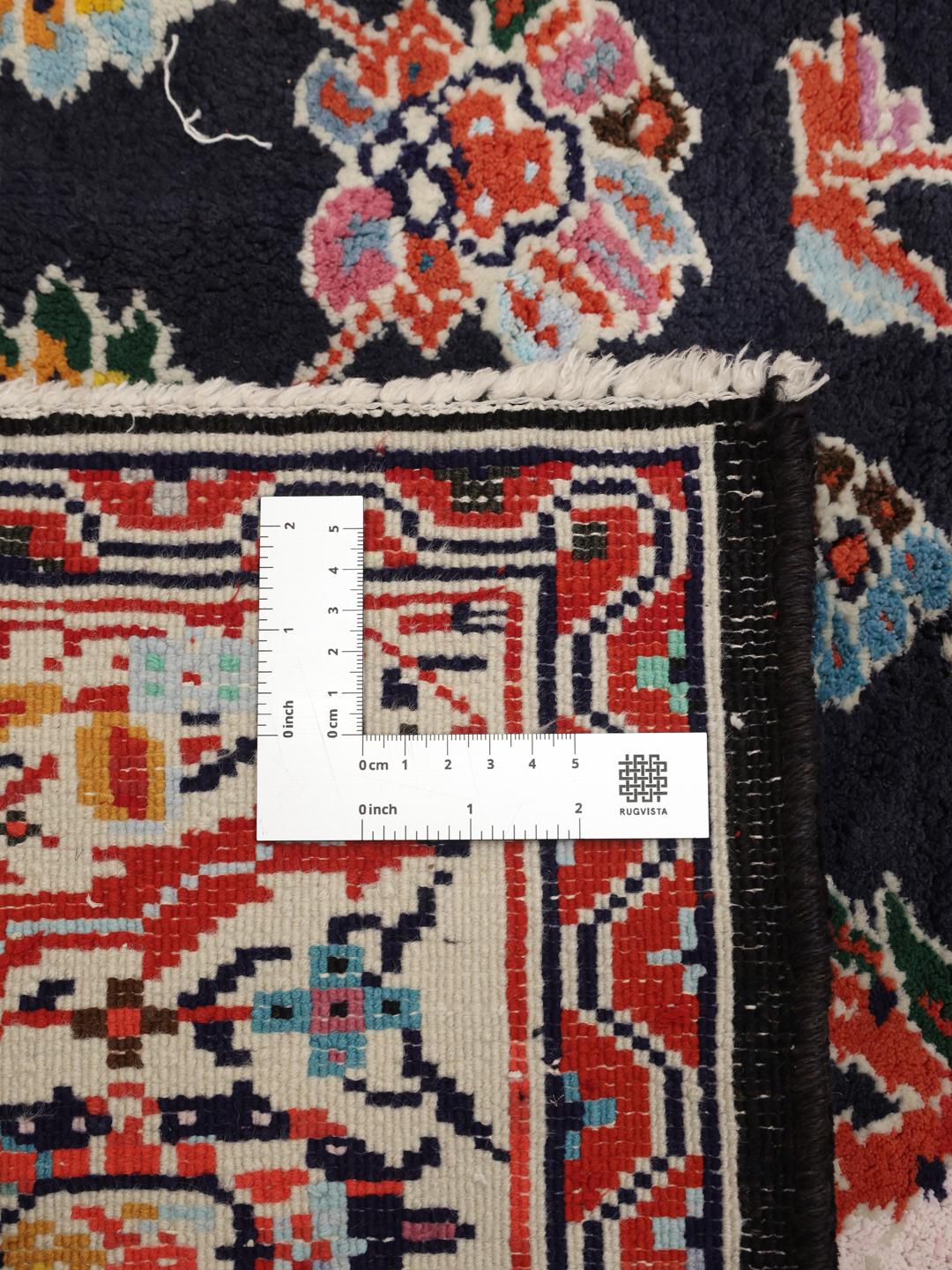 Hand-knotted Ardebil rug from the Middle East with a dark-blue and red floral medallion design.