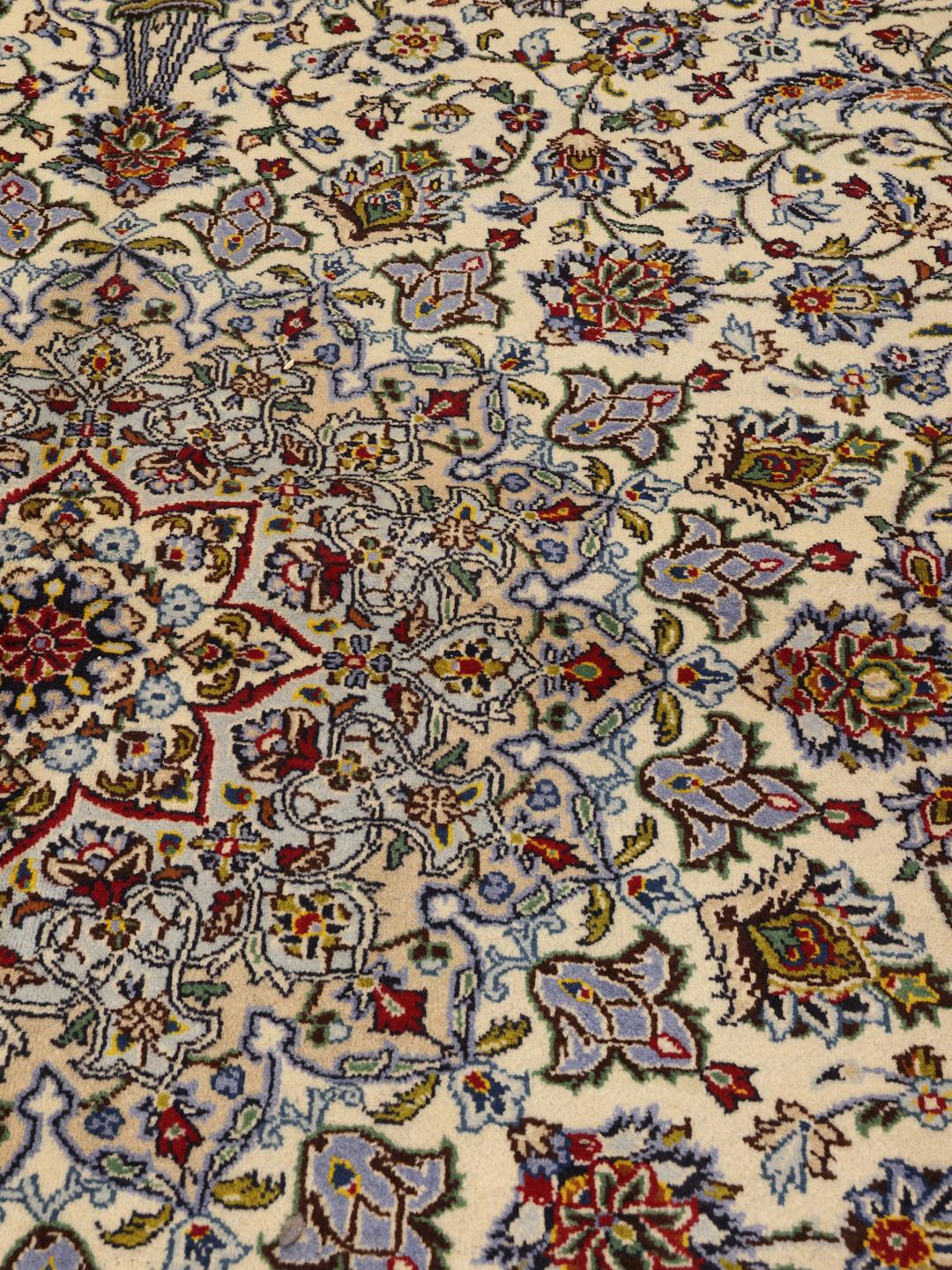 Et stort, håndknyttet Keshan-tæppe fra Mellemøsten med et beige felt og detaljerede blomstermønstre.