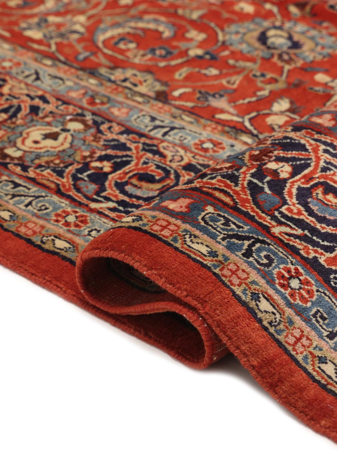 Een groot rechthoekig handgeknoopt Sarough-tapijt uit het Midden-Oosten met een rood en blauw bloemenpatroon.