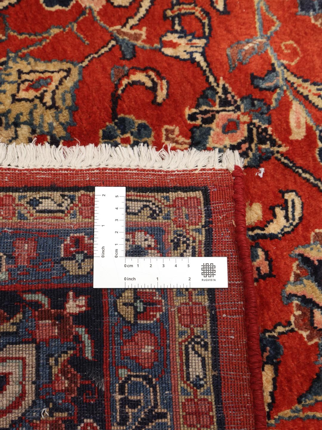 Een groot rechthoekig handgeknoopt Sarough-tapijt uit het Midden-Oosten met een rood en blauw bloemenpatroon.