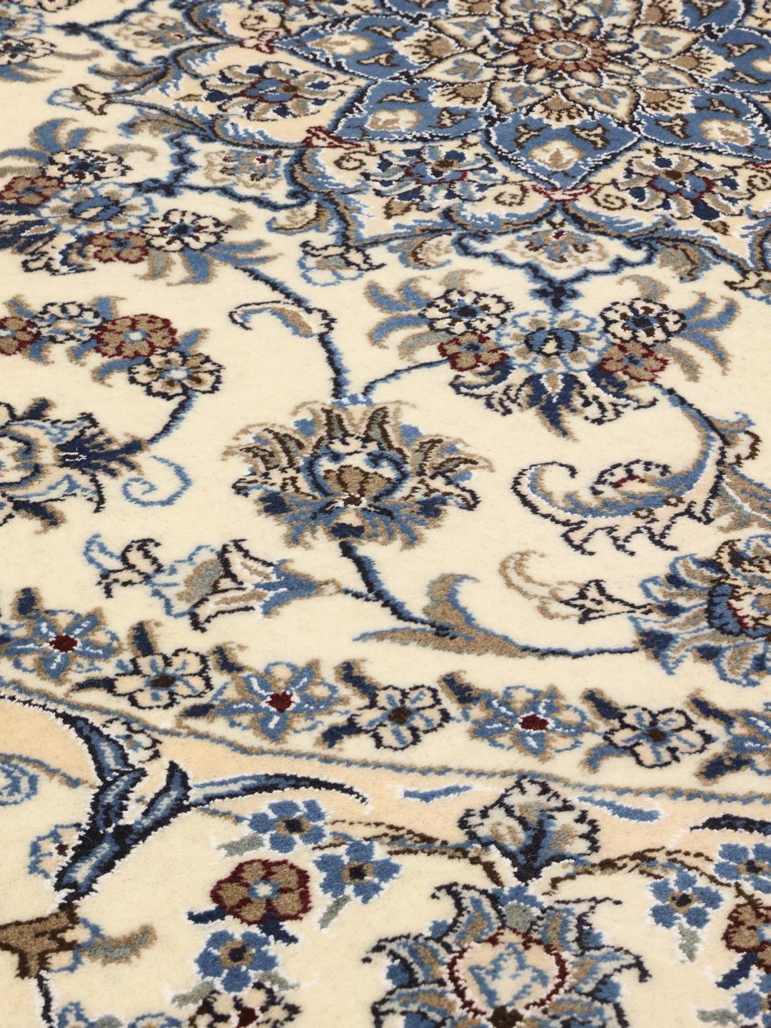 Tapis rond Nain du Moyen-Orient présentant des motifs floraux beiges et bleus.