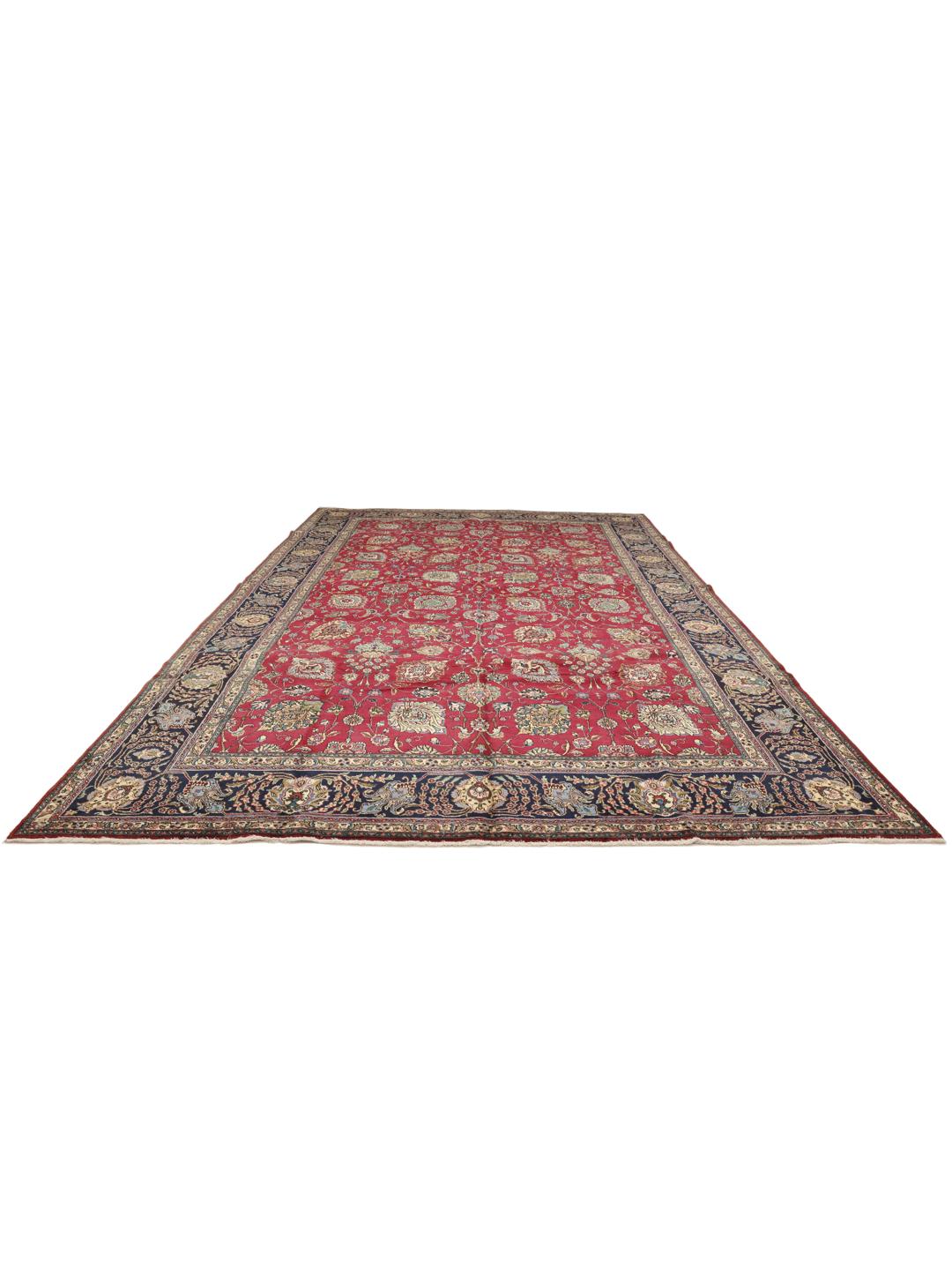 Een groot rechthoekig Tabriz-tapijt uit het Midden-Oosten met een rood veld en een blauwe rand.