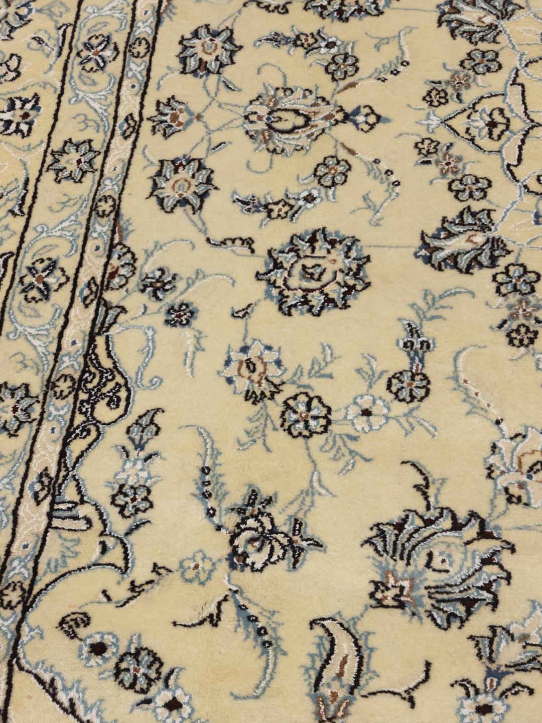 Un magnifique tapis Nain Fine 9La noué à la main, originaire du Moyen-Orient, dans des tons beige et bleu.