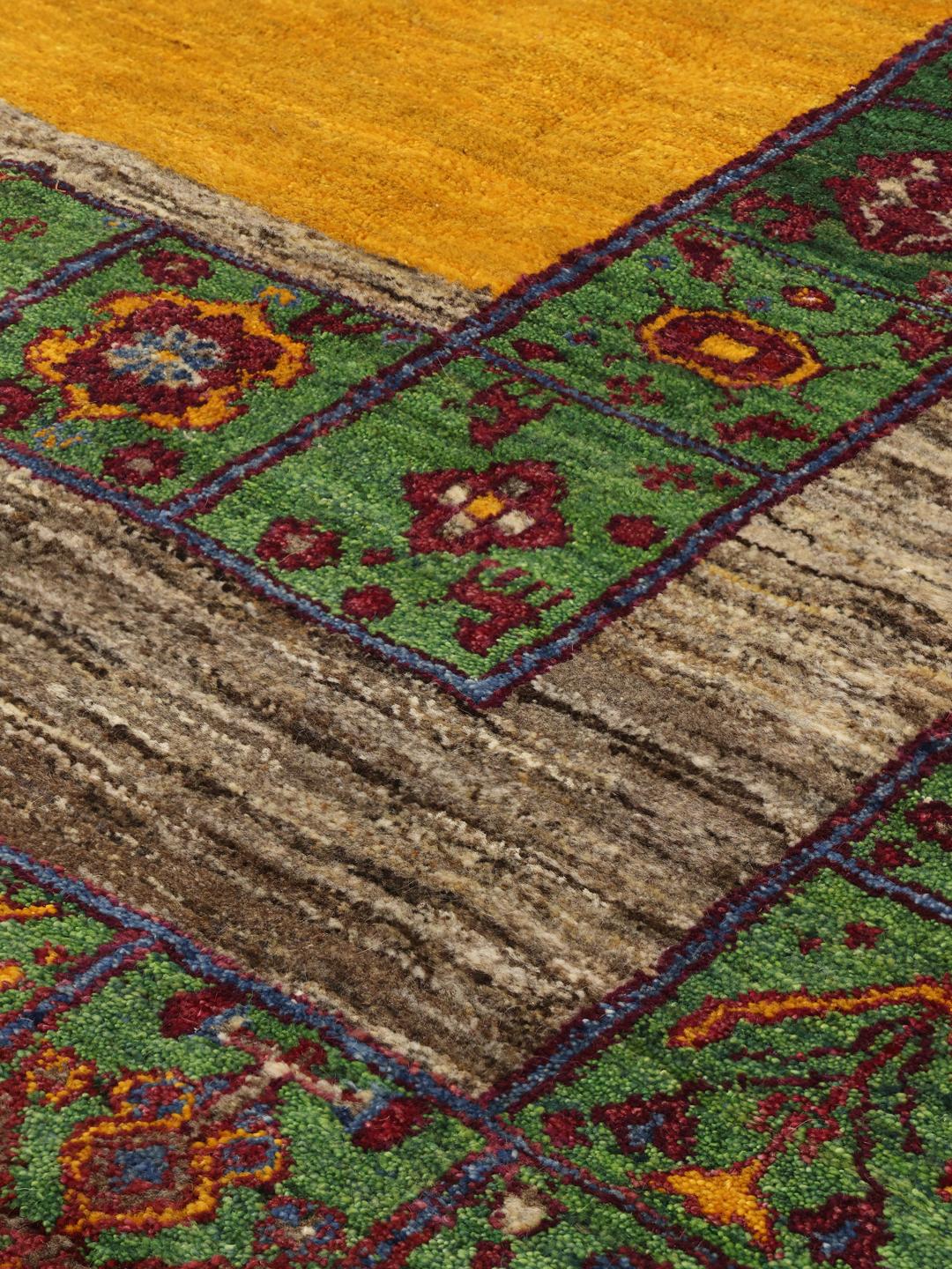 Et håndknyttet Gabbeh-tæppe fra Mellemøsten med et levende flerfarvet geometrisk og blomstret design.