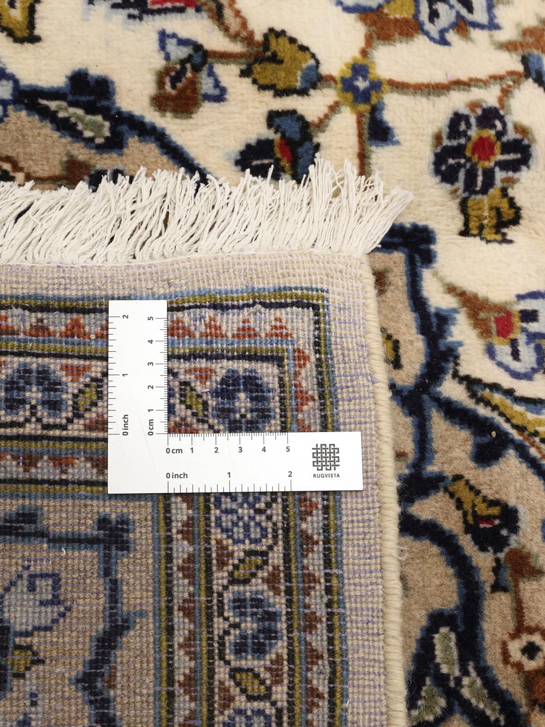 Et håndknyttet Keshan-tæppe fra Mellemøsten med et blomstermotiv og medaljon på en beige baggrund.