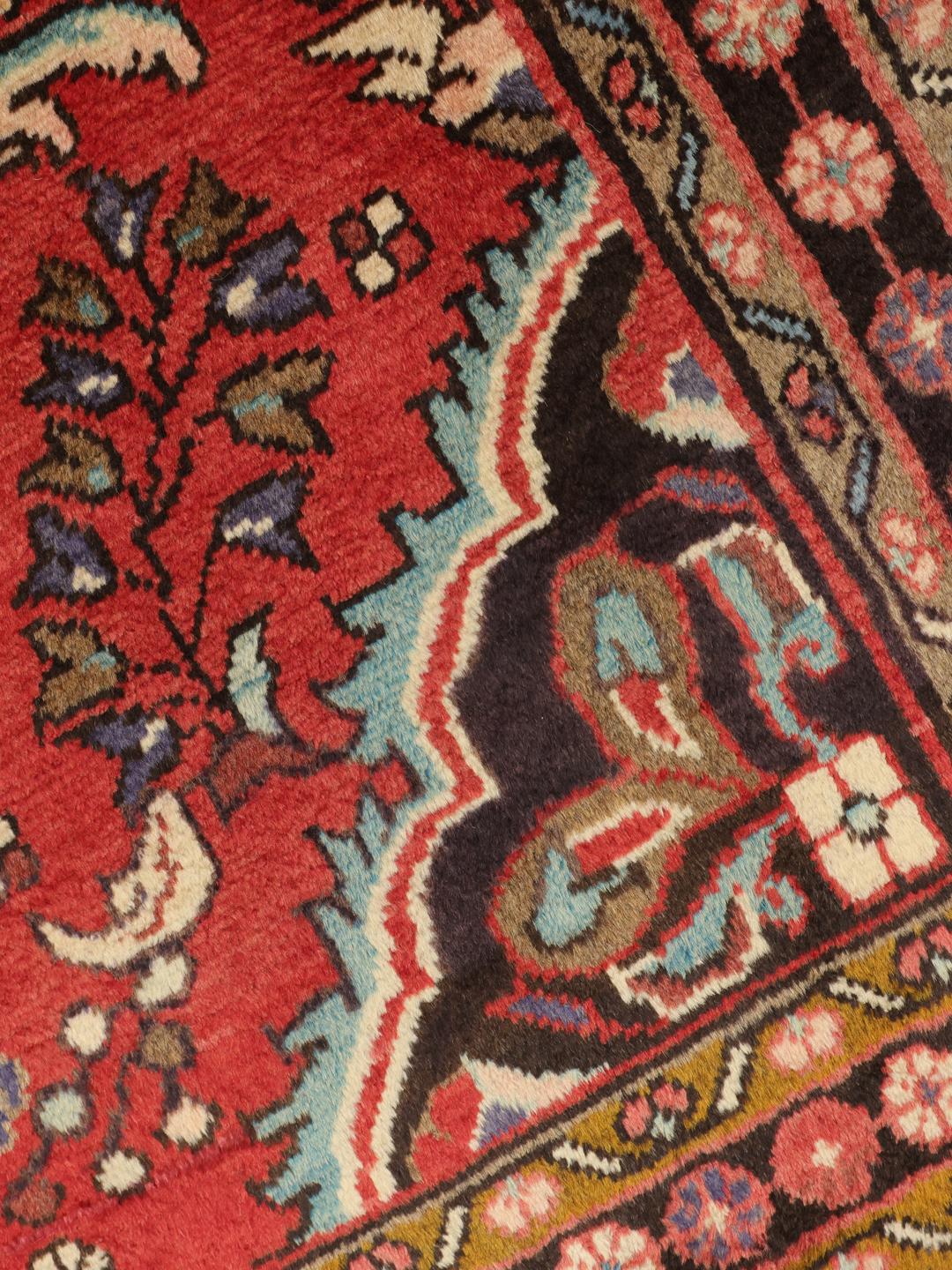 Een handgeknoopt Lillian-tapijt uit het Midden-Oosten met een rood veld en traditionele patronen.