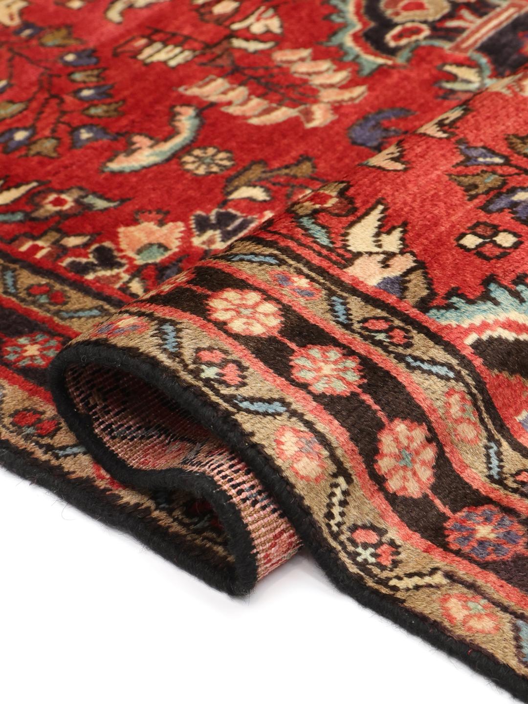 Een handgeknoopt Lillian-tapijt uit het Midden-Oosten met een rood veld en traditionele patronen.