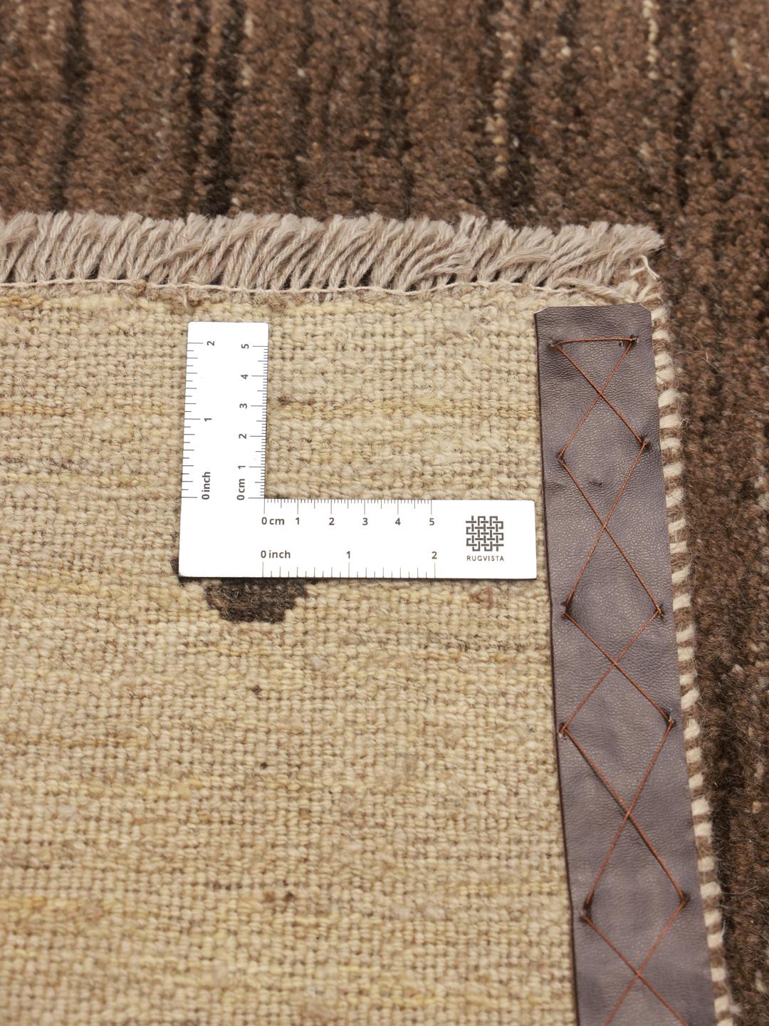 Hand-knotted Gabbeh rug with a brown field and beige border, Middle Eastern origin.