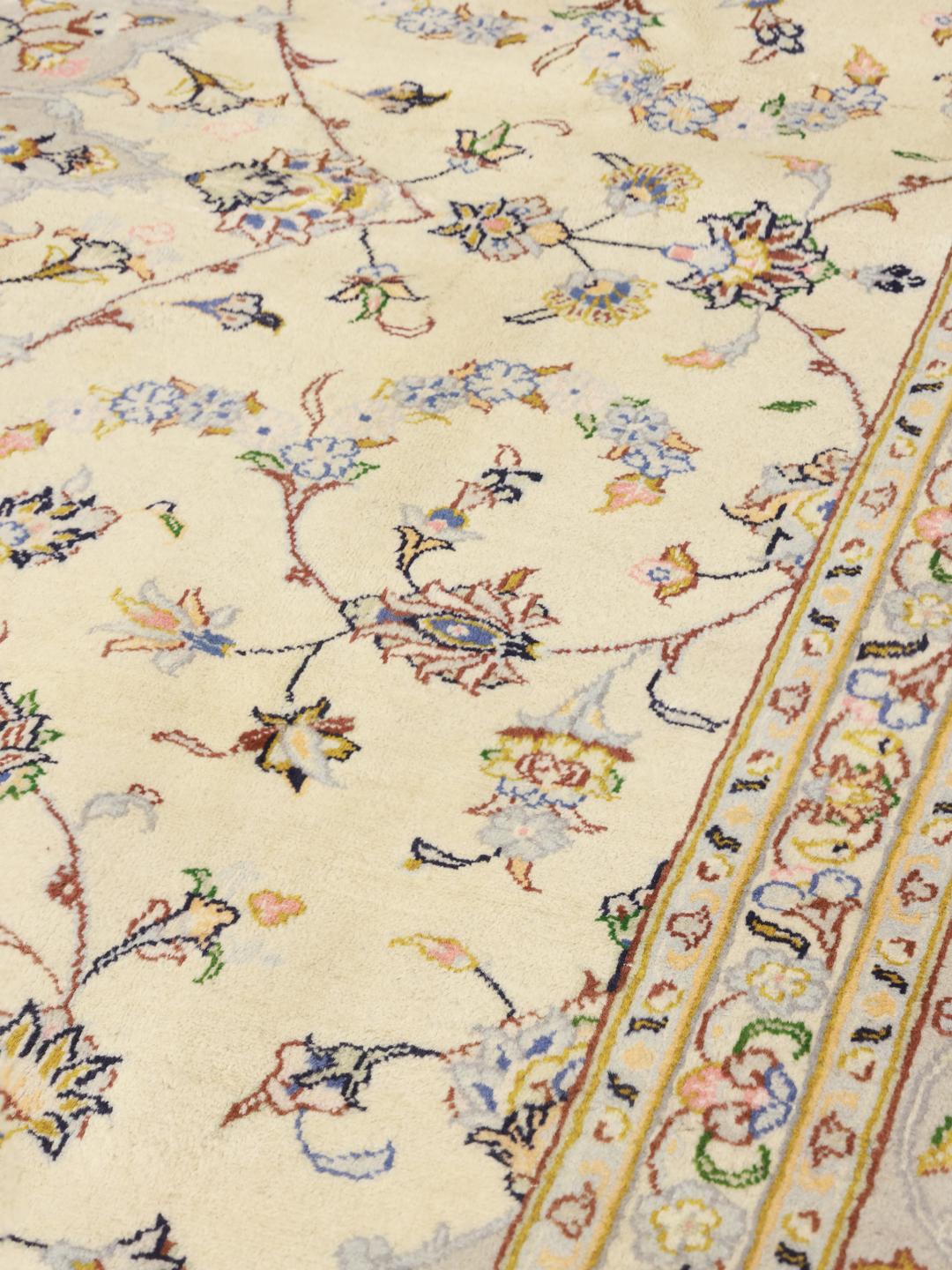 Handgeknoopt Keshan-tapijt uit het Midden-Oosten met een bloemmedaillon op een beige achtergrond.